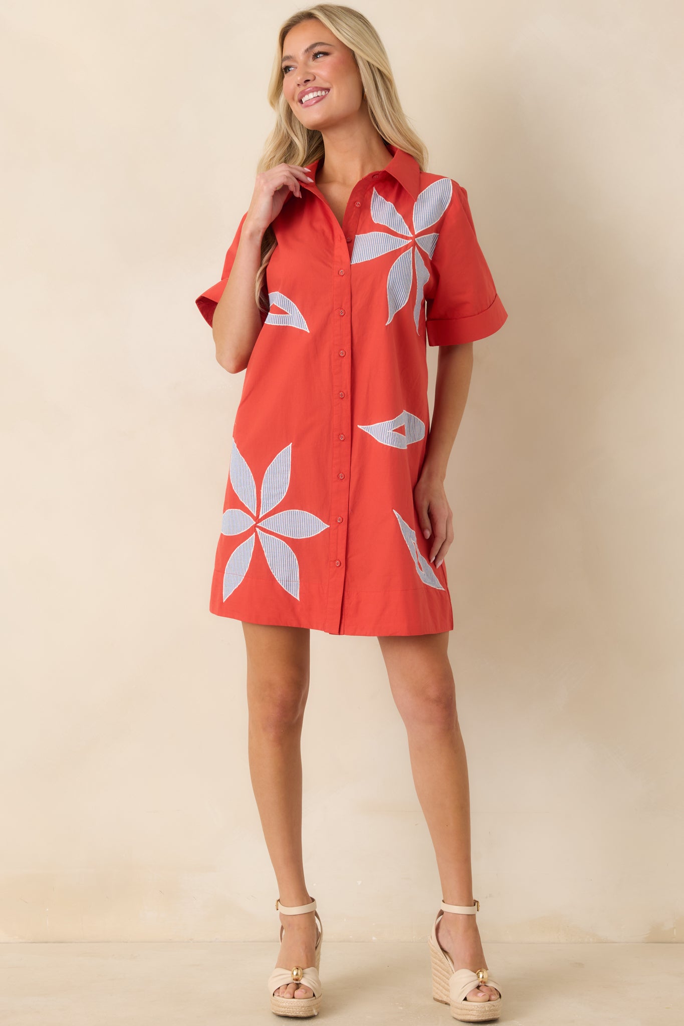 Blue and white stripe dress with relaxed shape, button front closure, and standout floral appliqué embellishments.