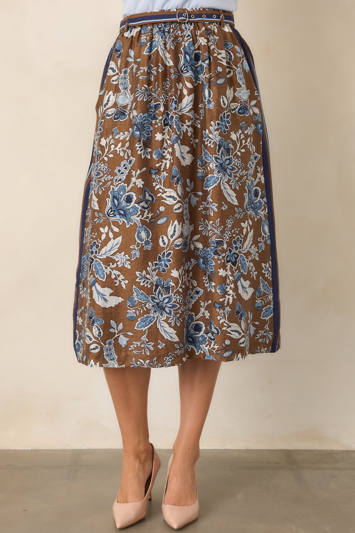 Blue and brown floral midi skirt featuring a defined high-rise waist, striped accents, and a softly flared A-line silhouette.