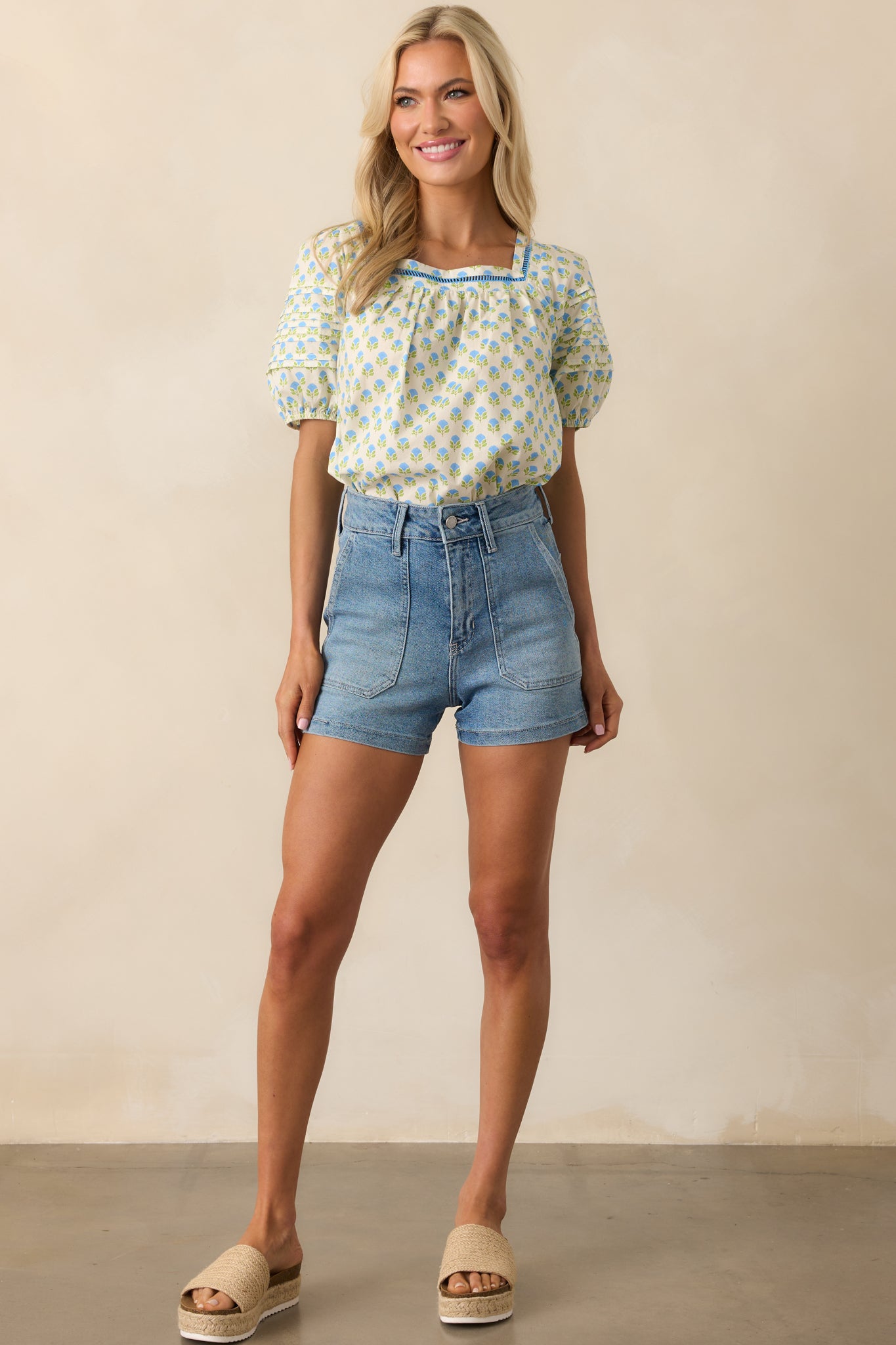 Blue floral cotton top with square neckline, ladder lace trim, short puff sleeves with elastic cuffs, and back self-tie closure.