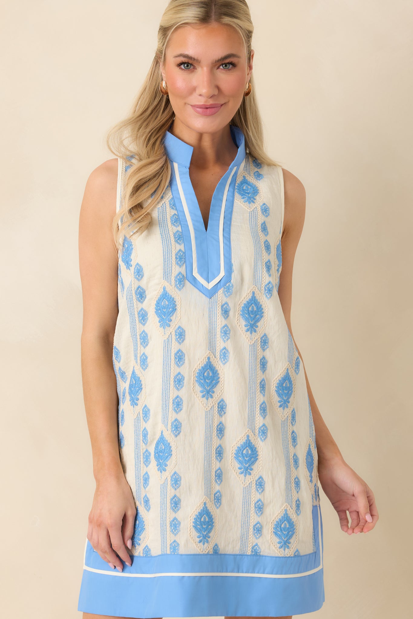Blue embroidered shift dress showcasing neckline detail and fine woven texture.