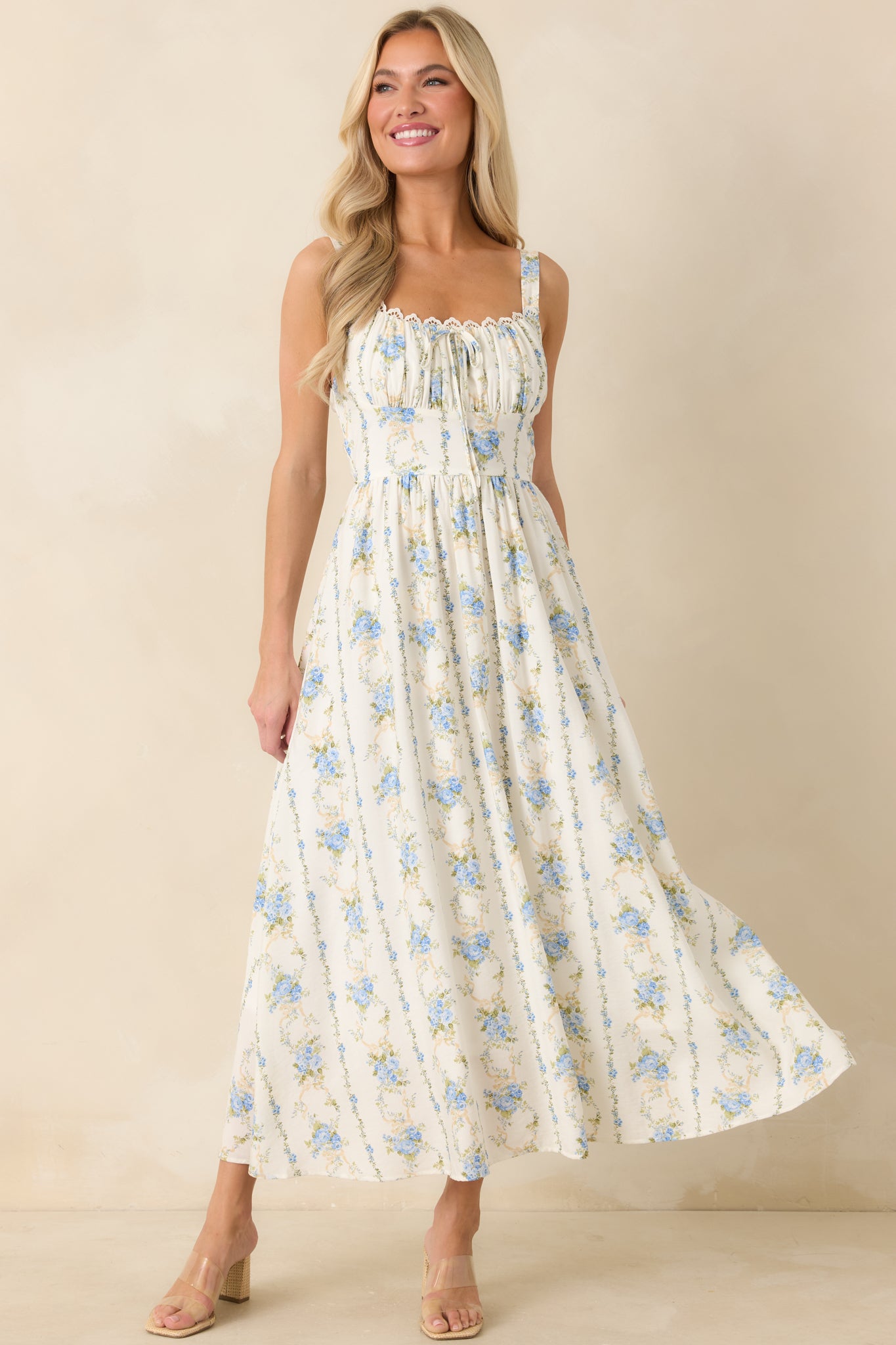 Blue floral midi dress with a gathered bodice, center bow accent, and a lightweight skirt that moves with ease.