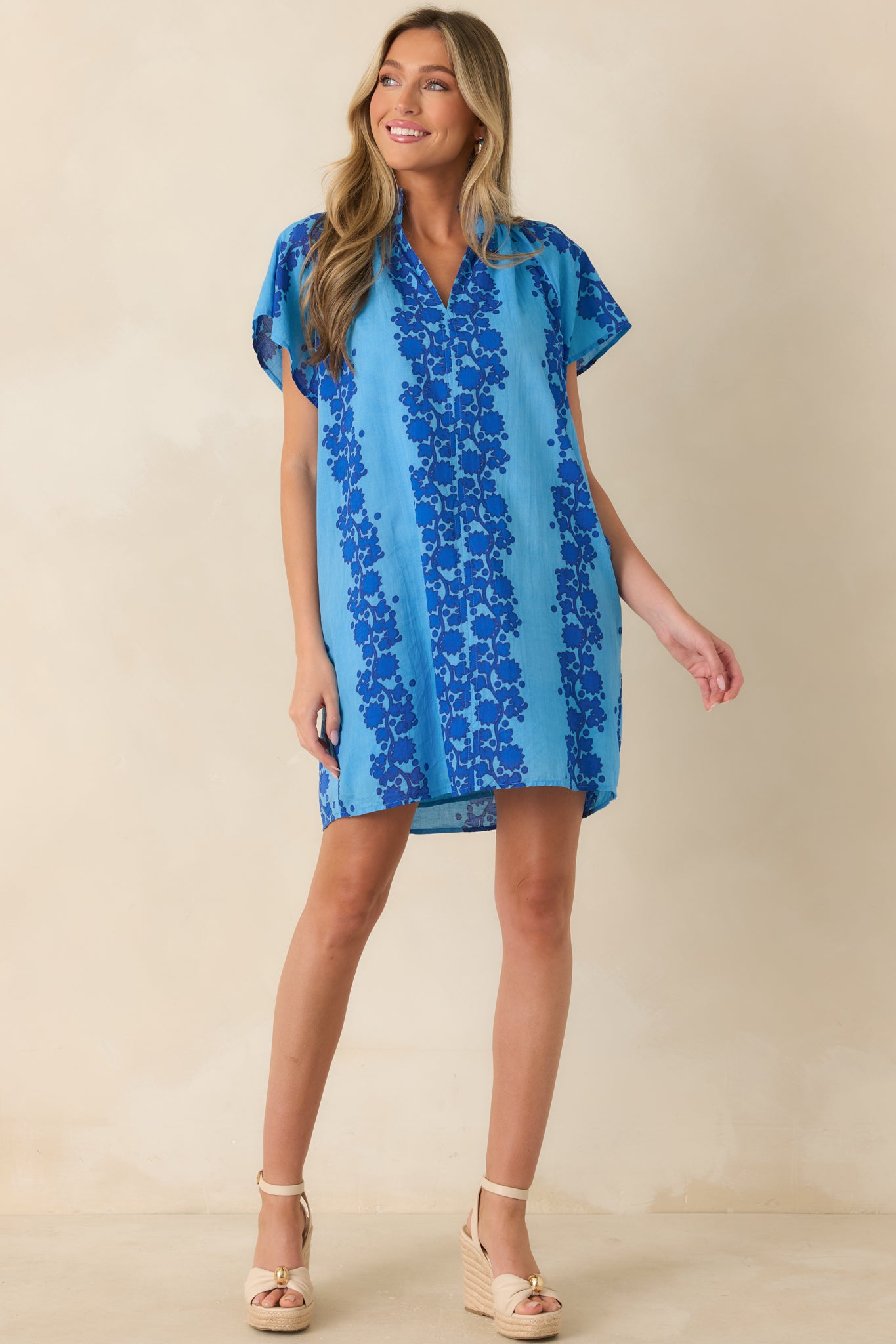 Blue floral mini dress designed with short sleeves, side pockets, and an easy loose-fitting silhouette.