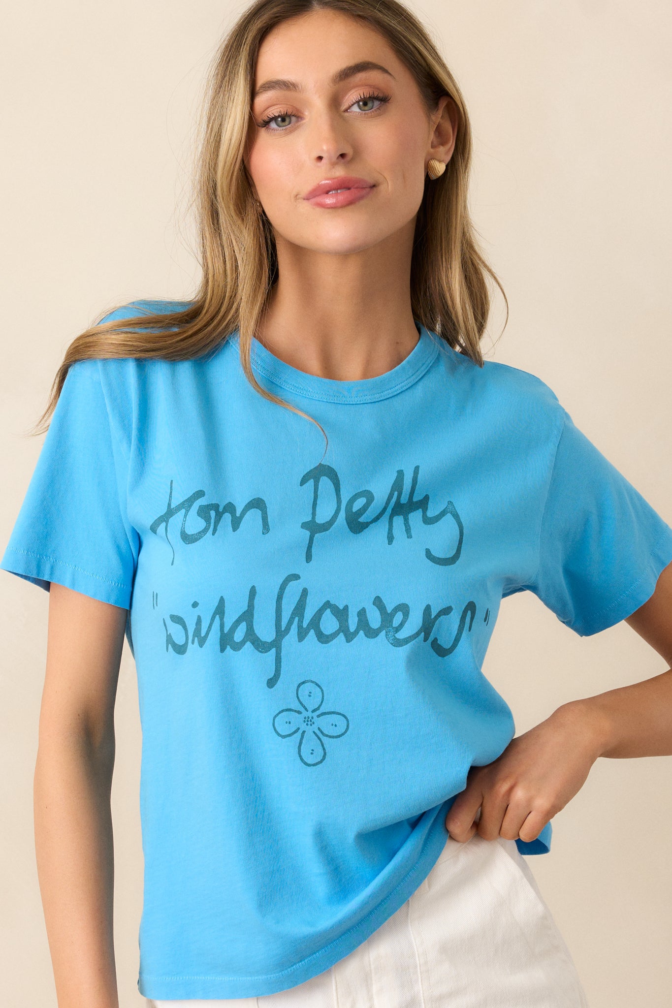 This blue tee showcases a reimagined graphic of the record "Wildflowers," with a crew neckline and short sleeves, offering a casual and laid-back vibe.