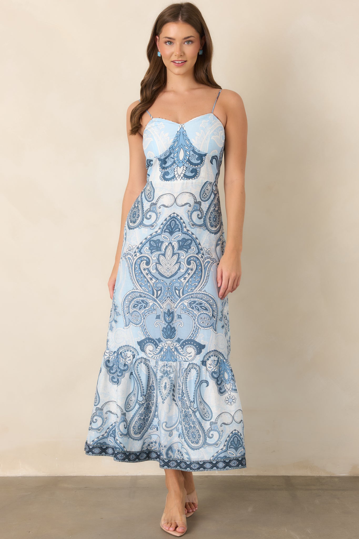 Feminine blue-and-ivory dress showcasing slender adjustable straps, decorative seed beads, and a graceful tiered midi silhouette.