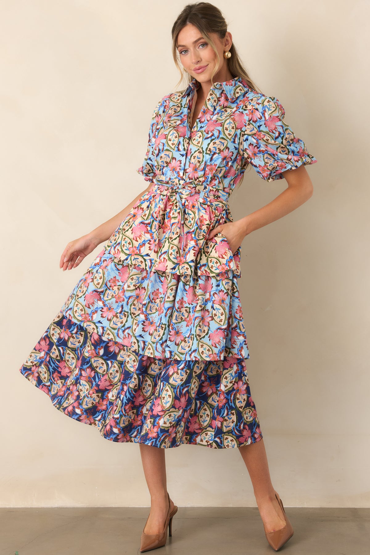 Blue and ivory botanical dress accented with pink blossoms, green vines, puff sleeves, and a coordinating waist tie.