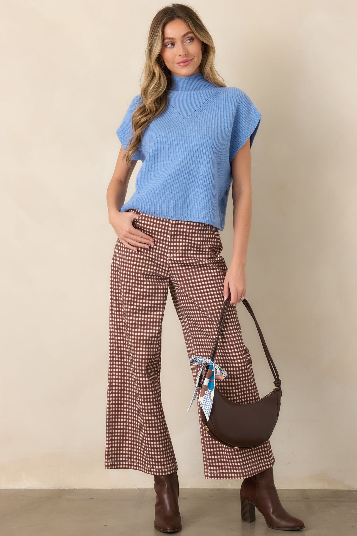 Blue knit top with a structured mock collar, delicate knit detailing across the chest, and a smooth straight hem.
