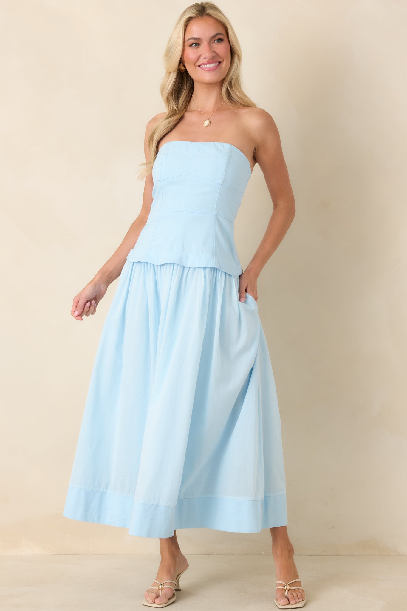 Classic blue midi dress designed with a corset-inspired bodice, defined panel construction, and a voluminous gathered silhouette.