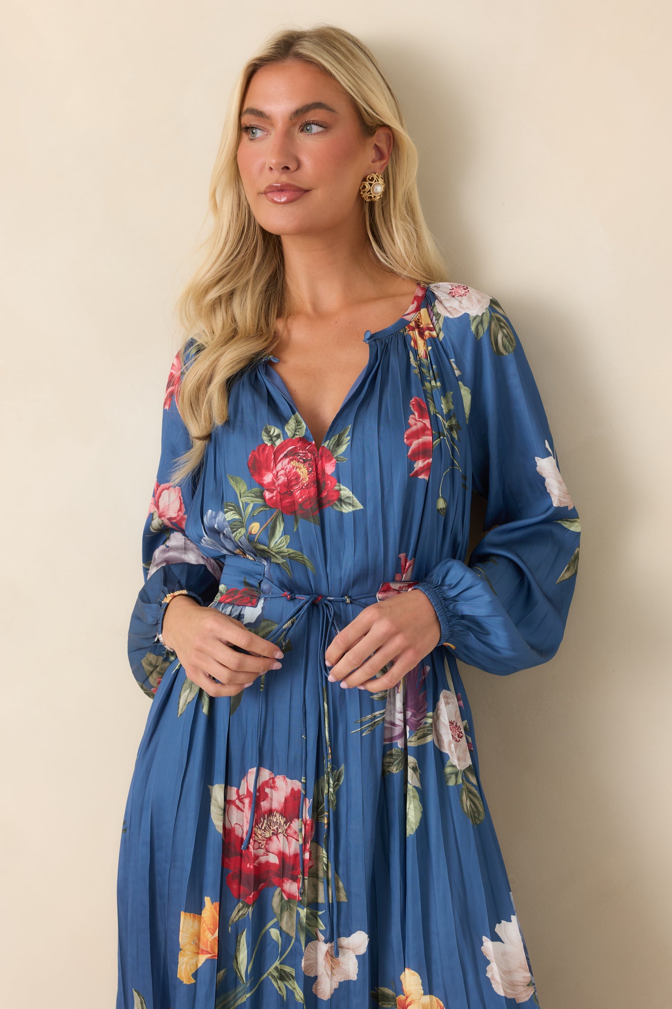 The upper portion of this blue midi dress highlights the gathered split neckline, oversized multicolor florals, and softly pleated texture.