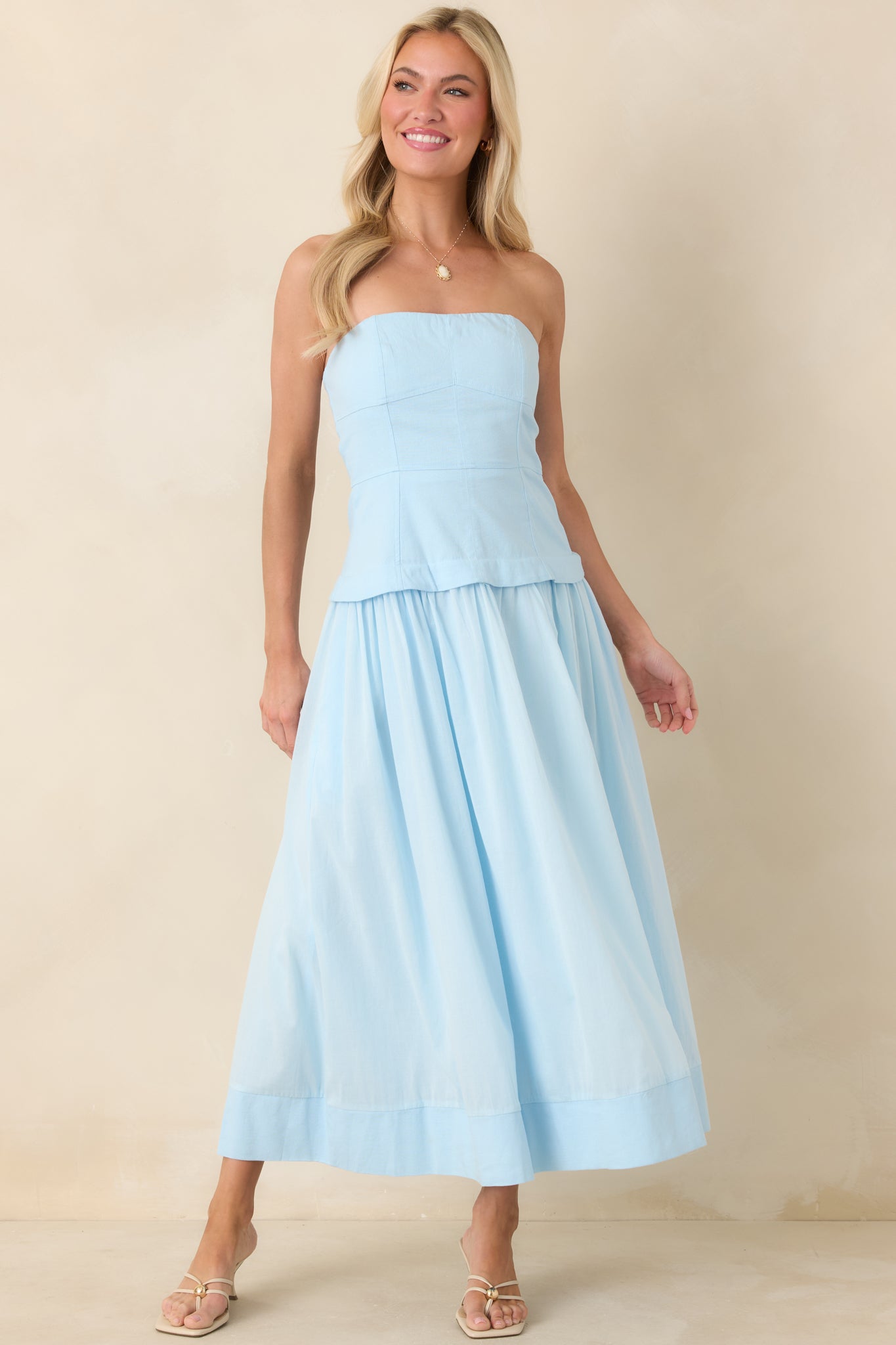Elegant blue midi showcasing sculpted bodice seams that lead into a fully lined skirt complete with functional side pockets.