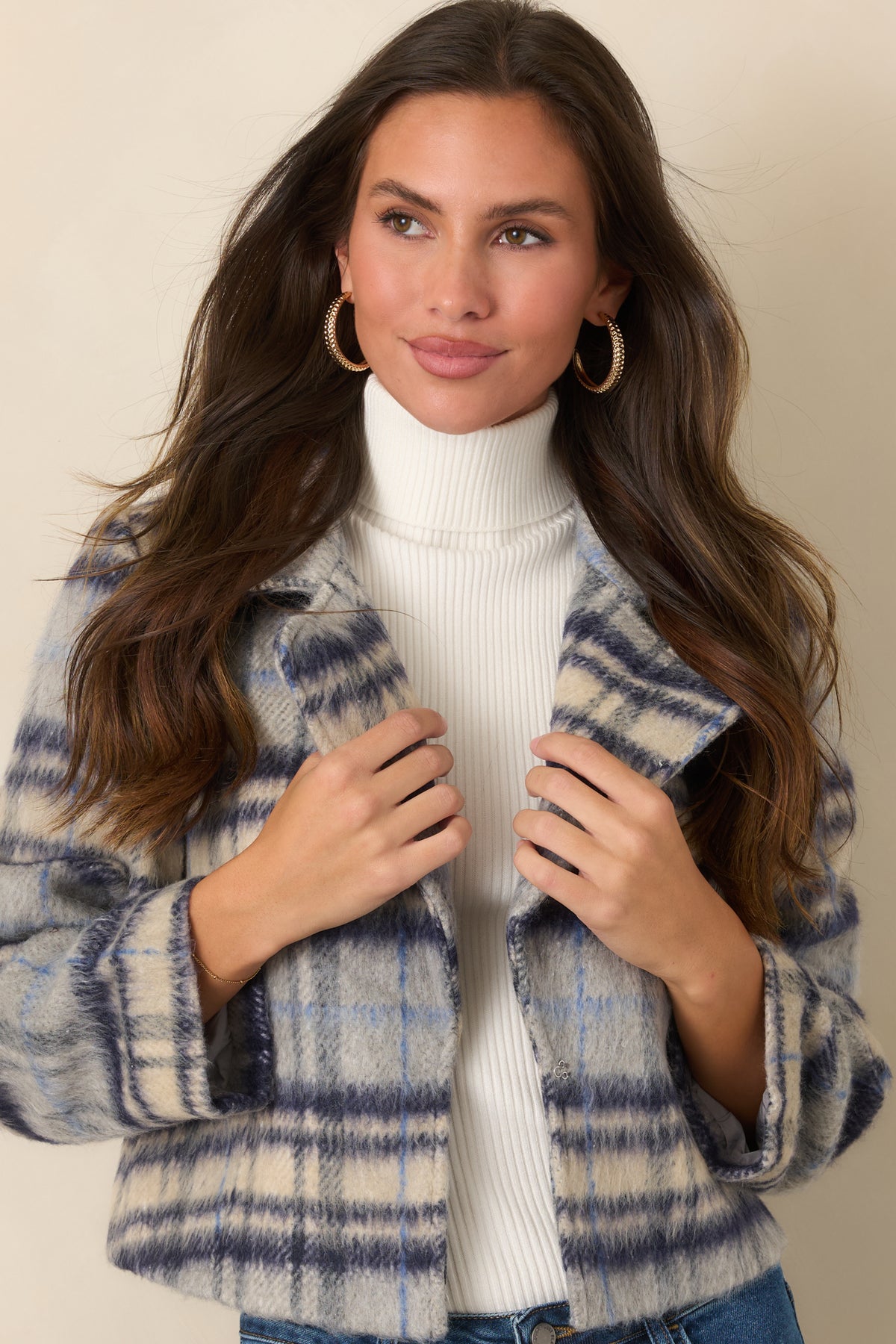 Blue, navy, and ivory plaid jacket showcasing its oversized notched lapels and cropped boxy shape.