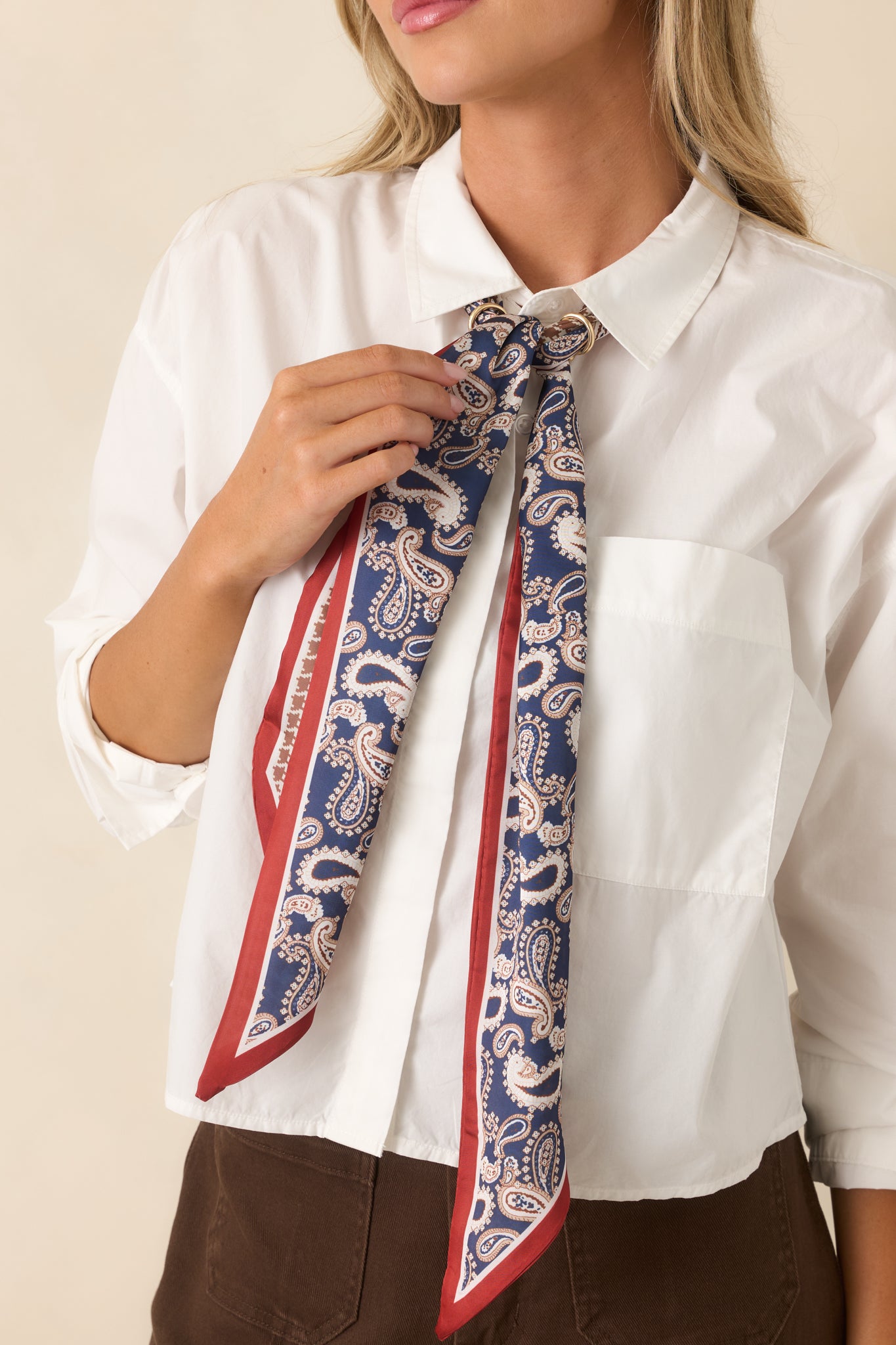 Slim silky accessory featuring blue paisley, camel houndstooth, and rust border patterns in a heritage-inspired design.
