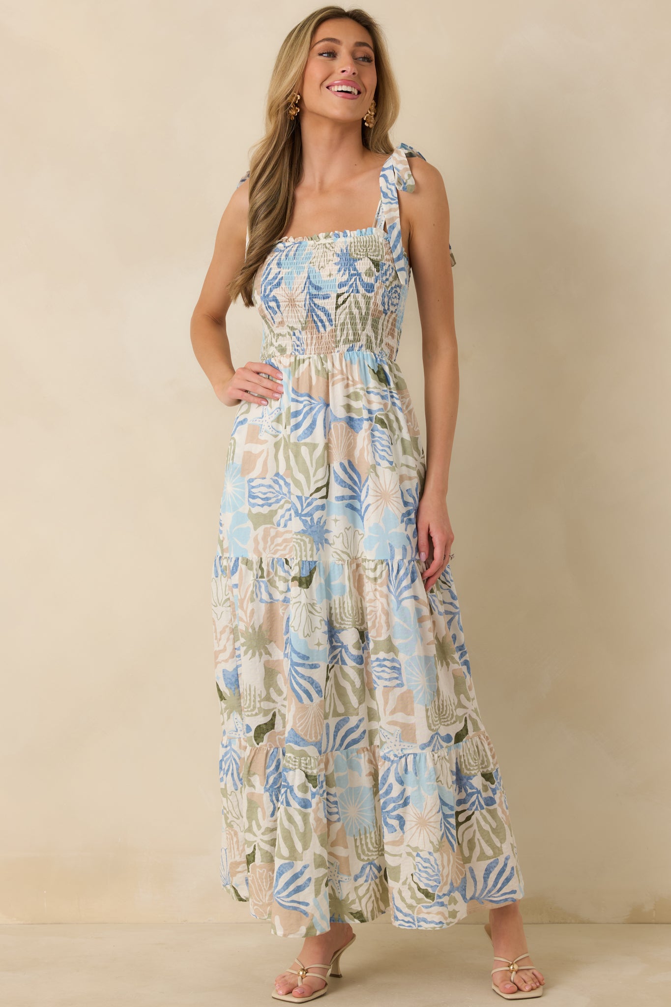 Blue palm and shell print dress showcasing the relaxed silhouette and breezy drape of the tiered skirt.