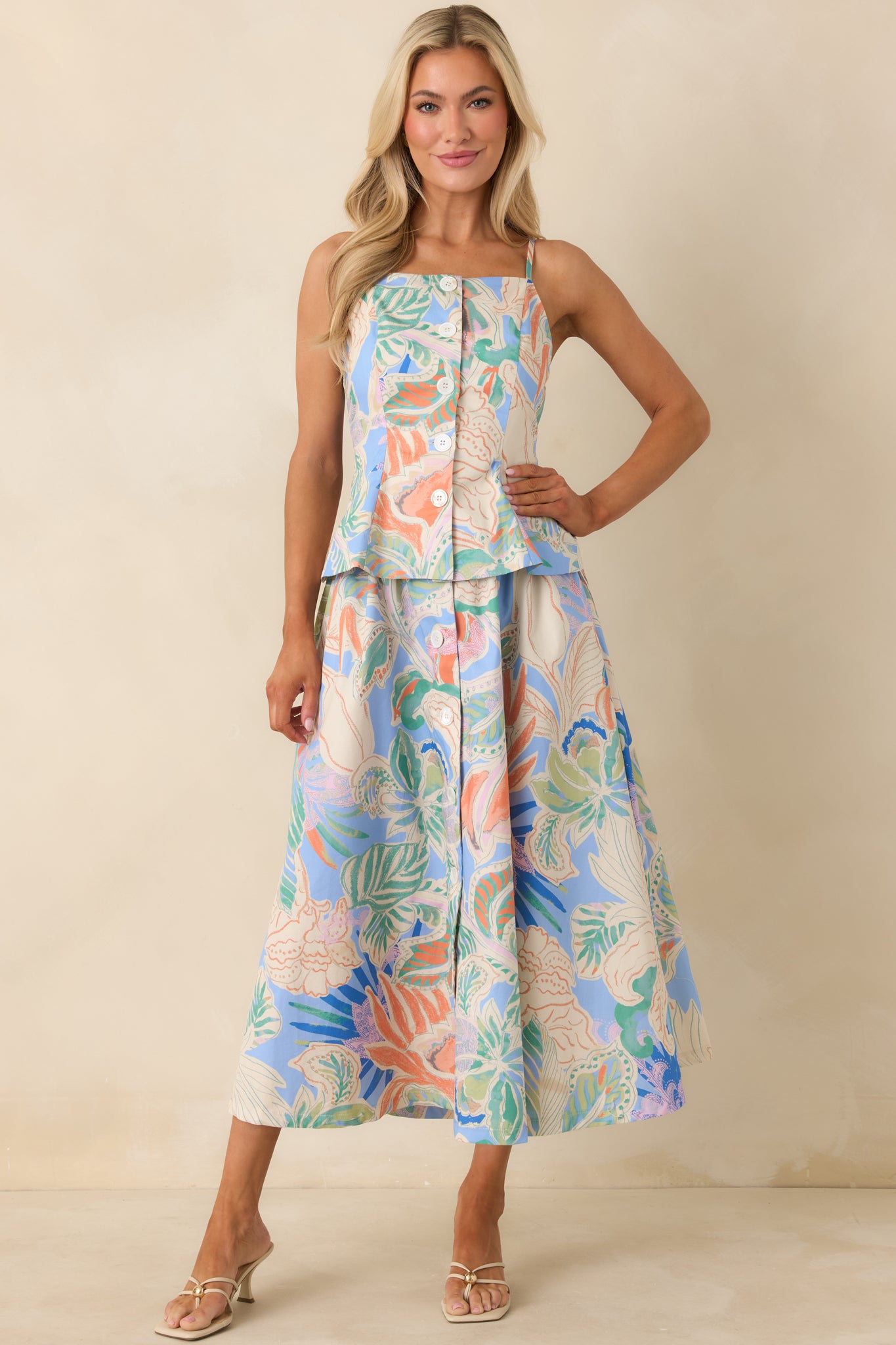 Blue patterned top with fitted bodice, peplum-style hem, and polished woven fabric finish.