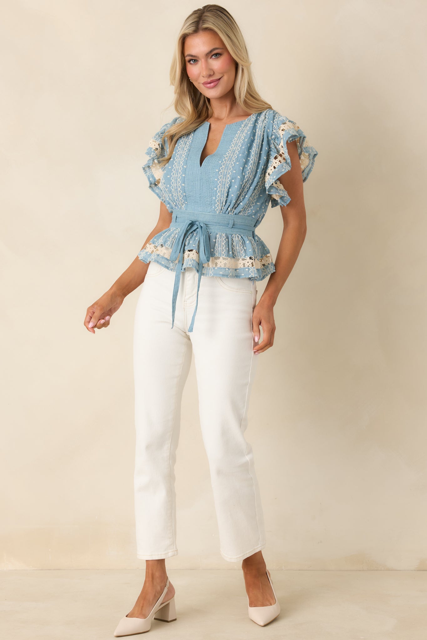 Blue peplum top with V-neckline, elastic back waistband, optional matching belt, and beige floral embroidered lace trim.