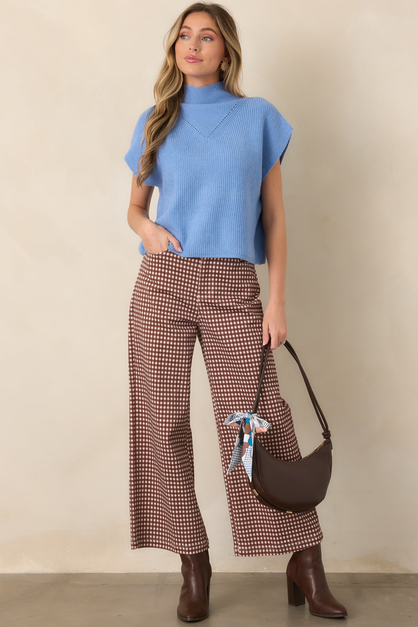 Blue ribbed knit top featuring a mock neckline, cap sleeves, subtle chest detailing, and a clean hemline.