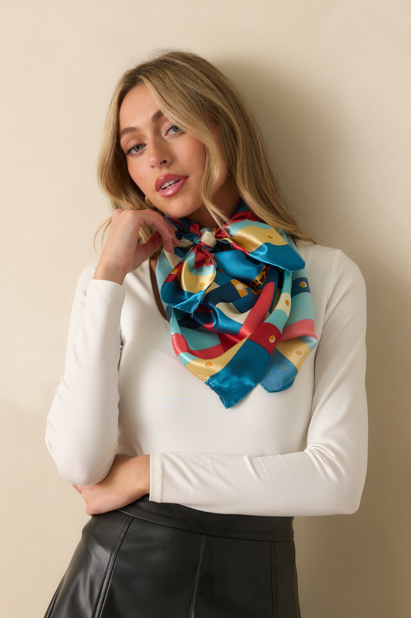 A blue satin scarf with a bold multi-color chain print, accented by vibrant gold, pink, yellow, teal, and blue details along the corners and sides.