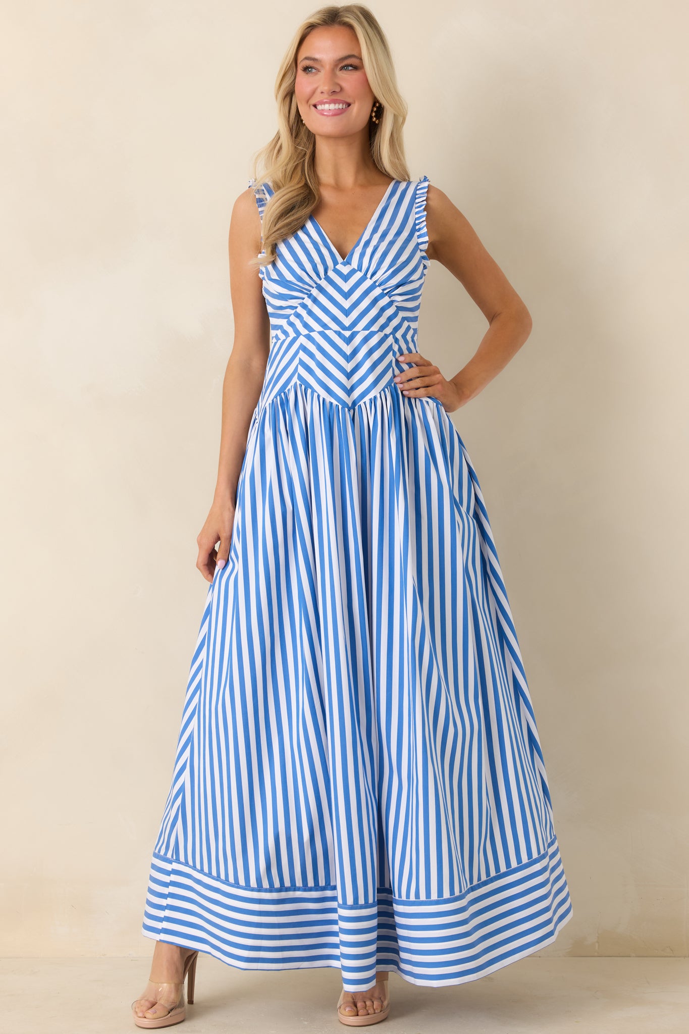 Close-up detail of blue stripe dress showing chevron bodice pattern, smocked sides, and gathered fabric.