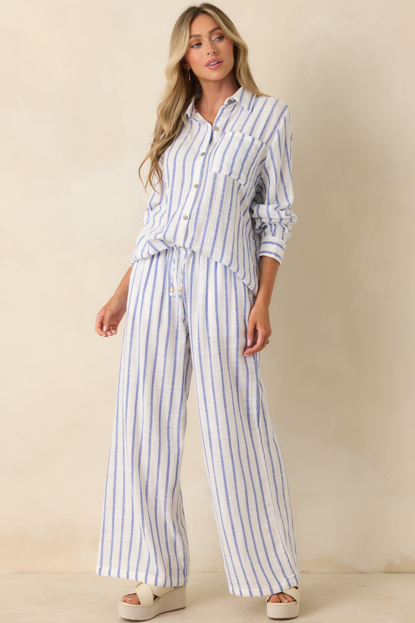 Blue stripe pants featuring a lightweight gauzy cotton fabric, high-rise elastic waistband, and relaxed wide-leg silhouette.