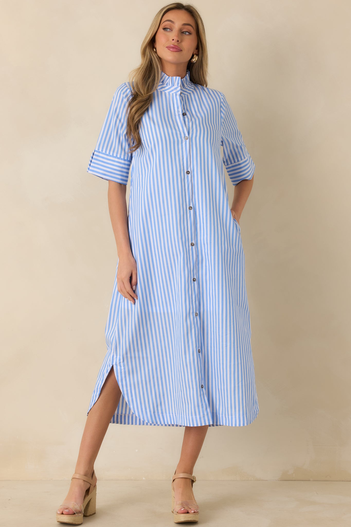 Blue striped midi shirt dress featuring a button-front closure, ruffled collar, and relaxed flowy skirt.