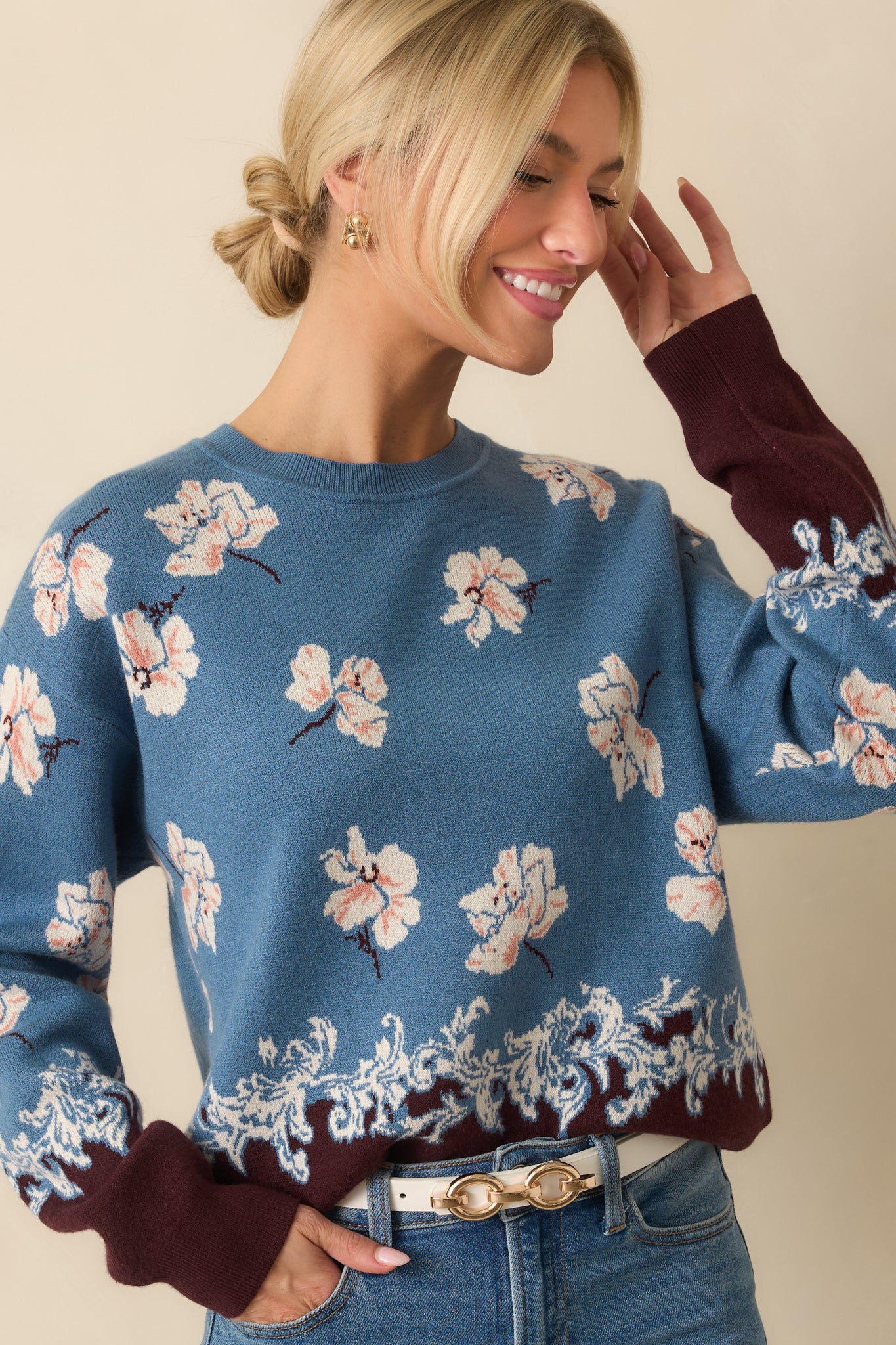 Detail of the ribbed cuff and ivory floral knit texture on the sleeve.