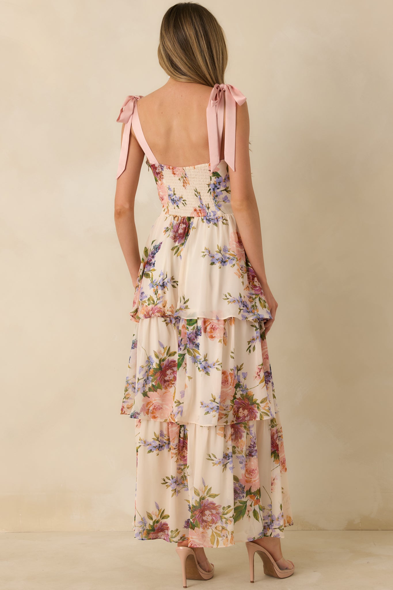 Blush pink multi floral maxi dress showing the smocked back panel and adjustable tie shoulder straps.