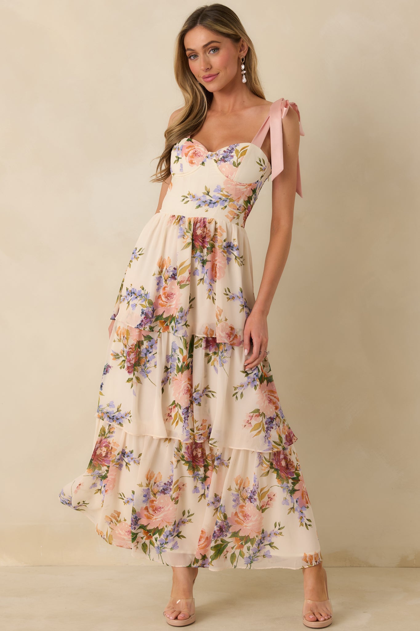 Blush pink multi maxi dress designed with tie straps, a fitted bodice, and a flowing tiered hem.