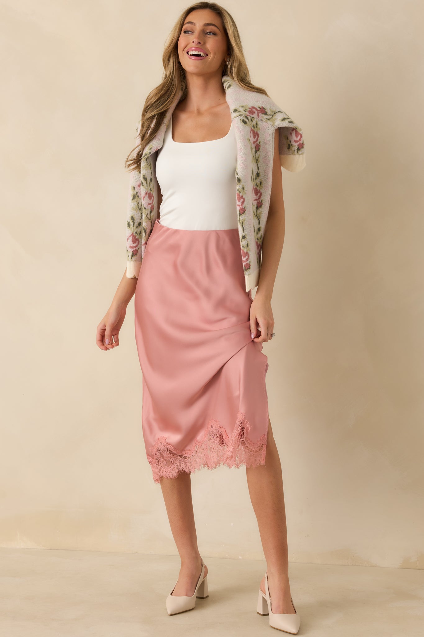 Full view of the blush satin midi skirt emphasizing the pull-on design and elegant midi length.