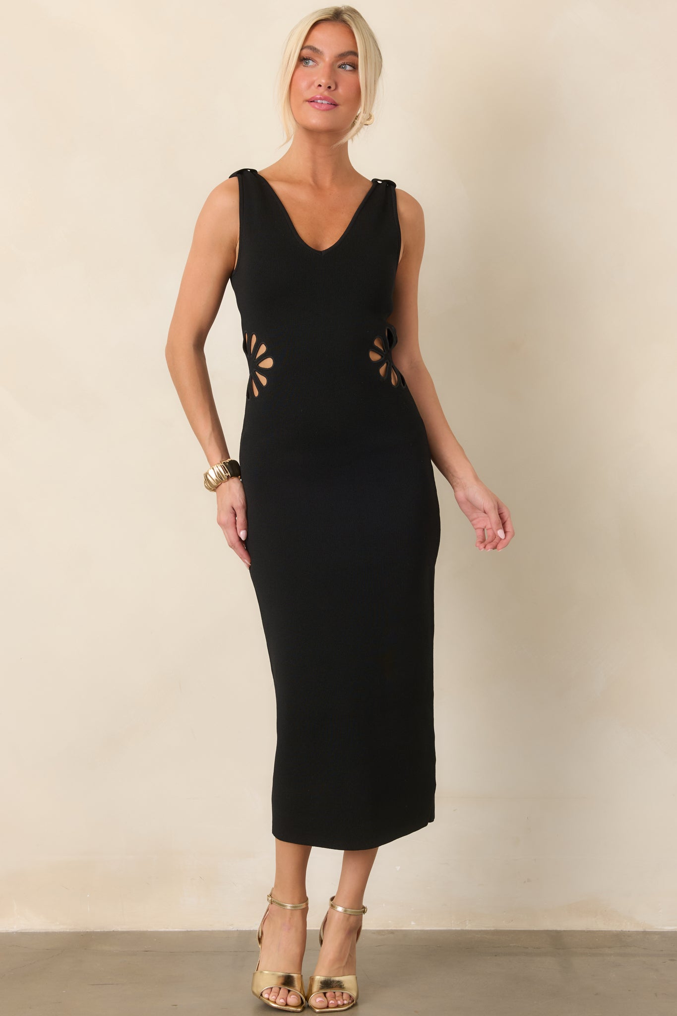 Body-skimming stretch-knit midi dress highlighting the clean V-neckline, wide straps, and sculpted waist with floral-inspired side cutouts.
