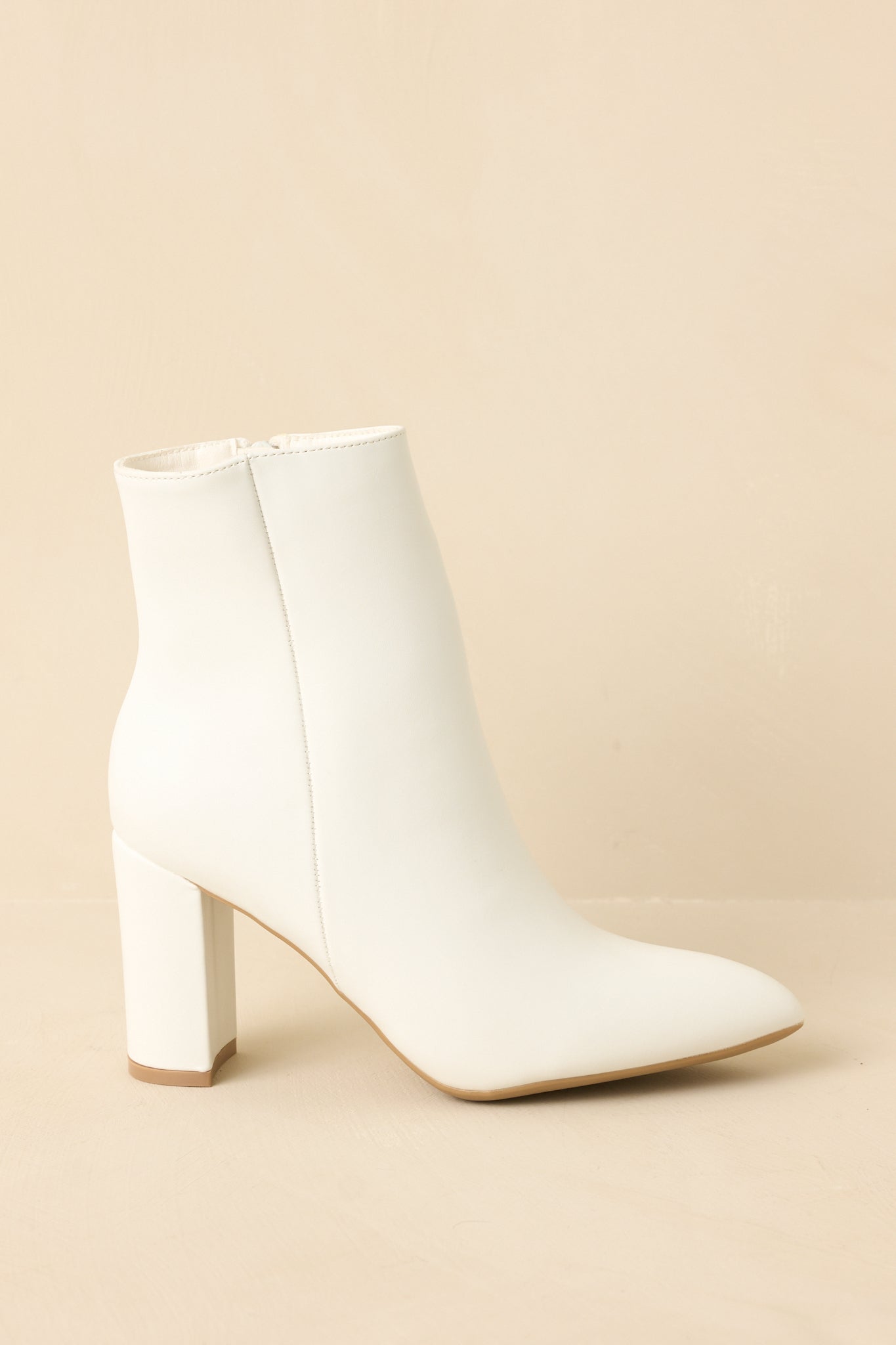 Boots angled to highlight the outer seam detail and inner zipper closure.
