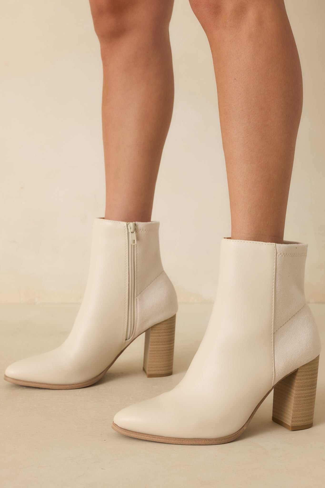 A cropped side angle highlighting the tonal faux suede back panel and inner side zipper closure.