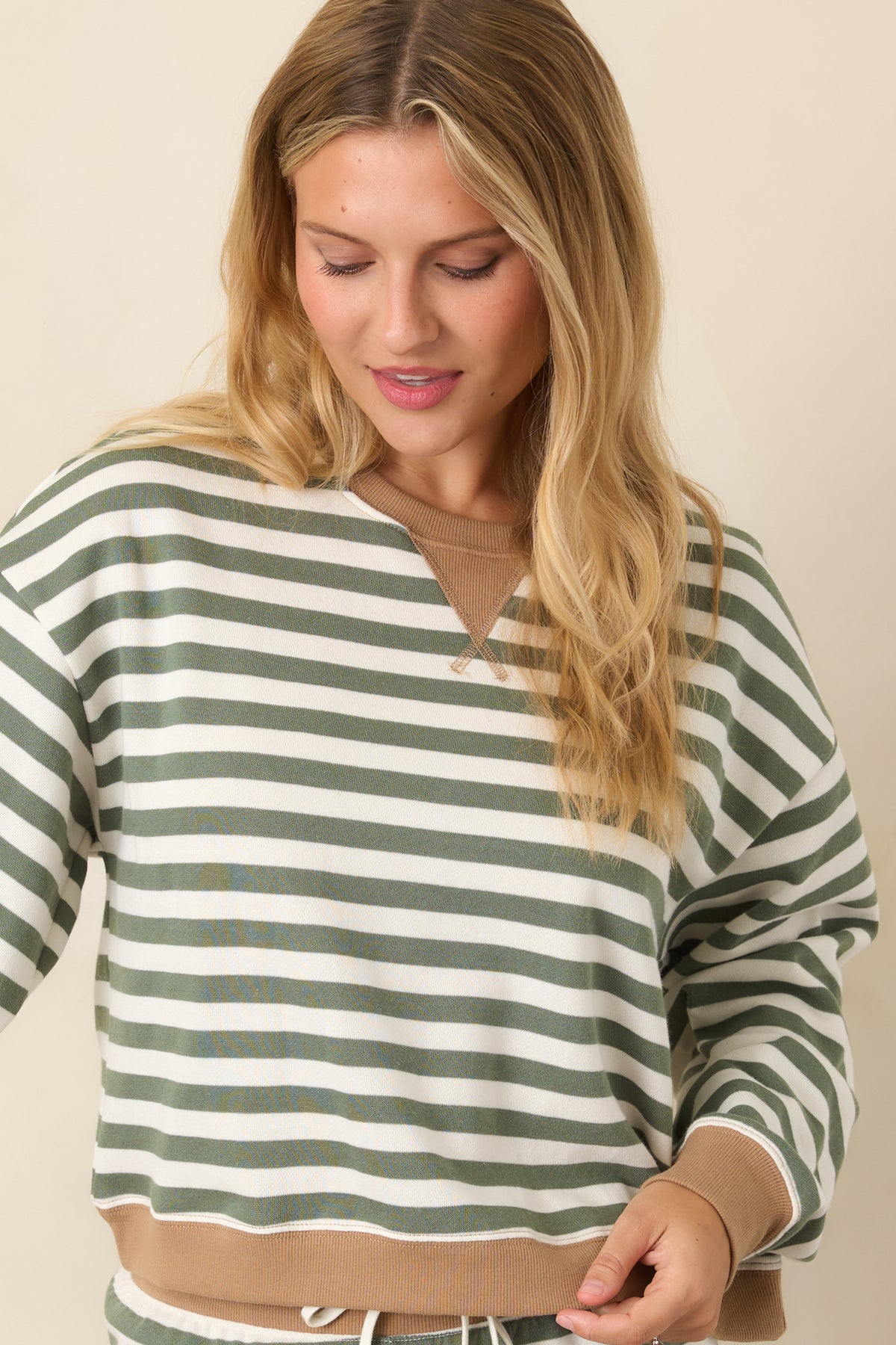 Botanical green and ivory striped sweatshirt highlighting the stitched triangular neckline insert and contrasting camel ribbed collar.