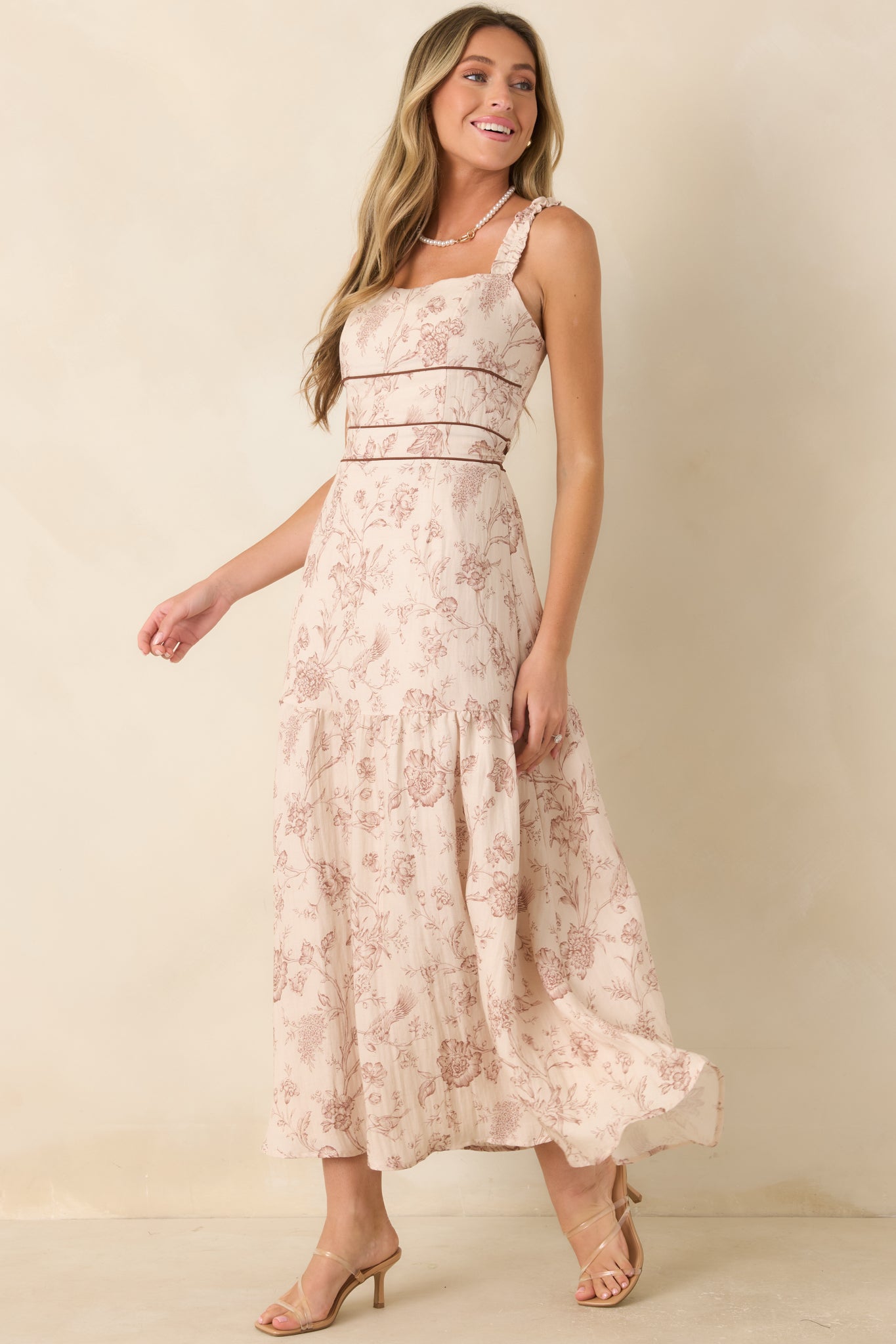 Botanical print maxi dress featuring a square neckline, structured waist detail, and soft flowing layers throughout the skirt.
