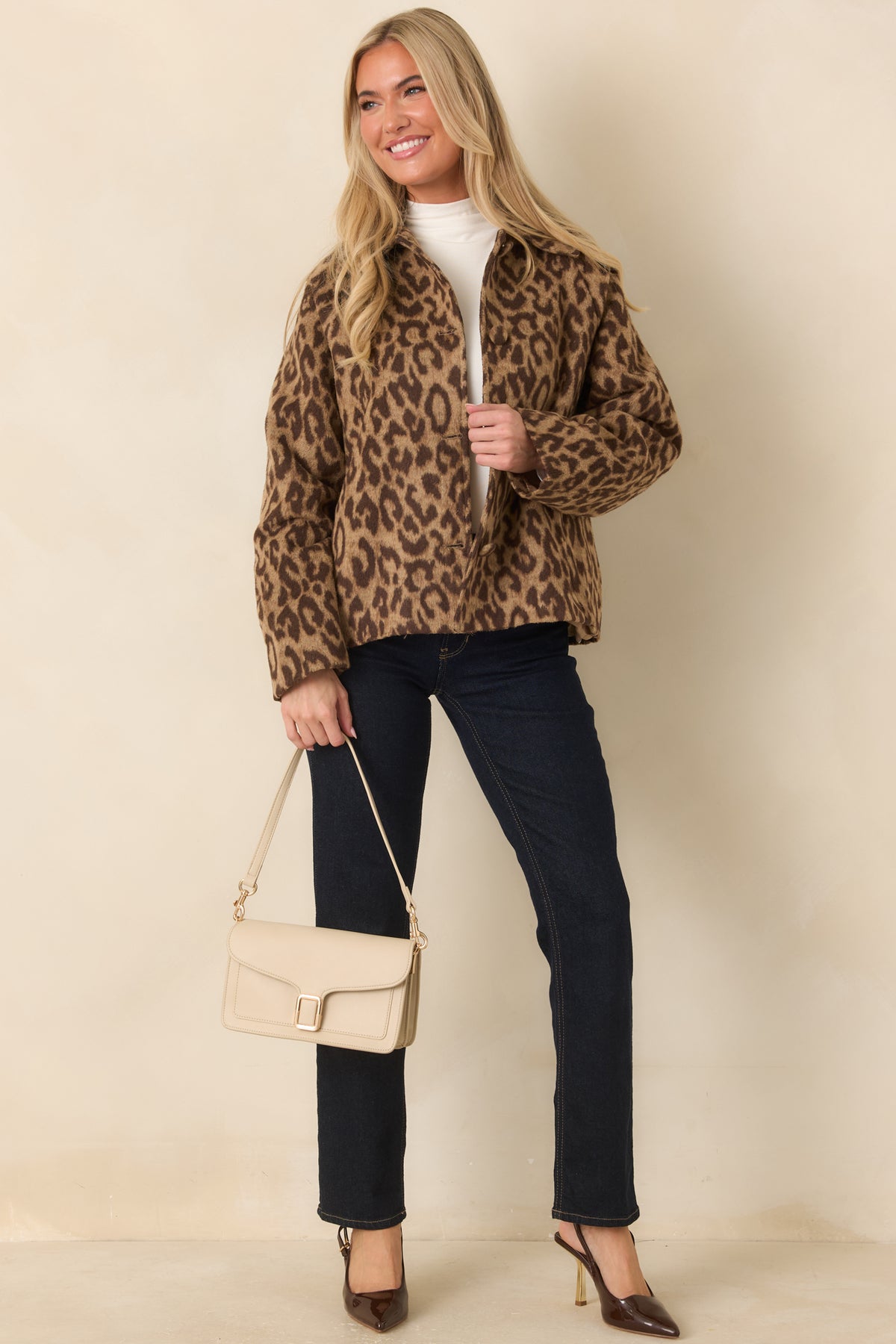 Boxy camel jacket with bold brown leopard spots, a button-front closure, and a soft textured finish.
