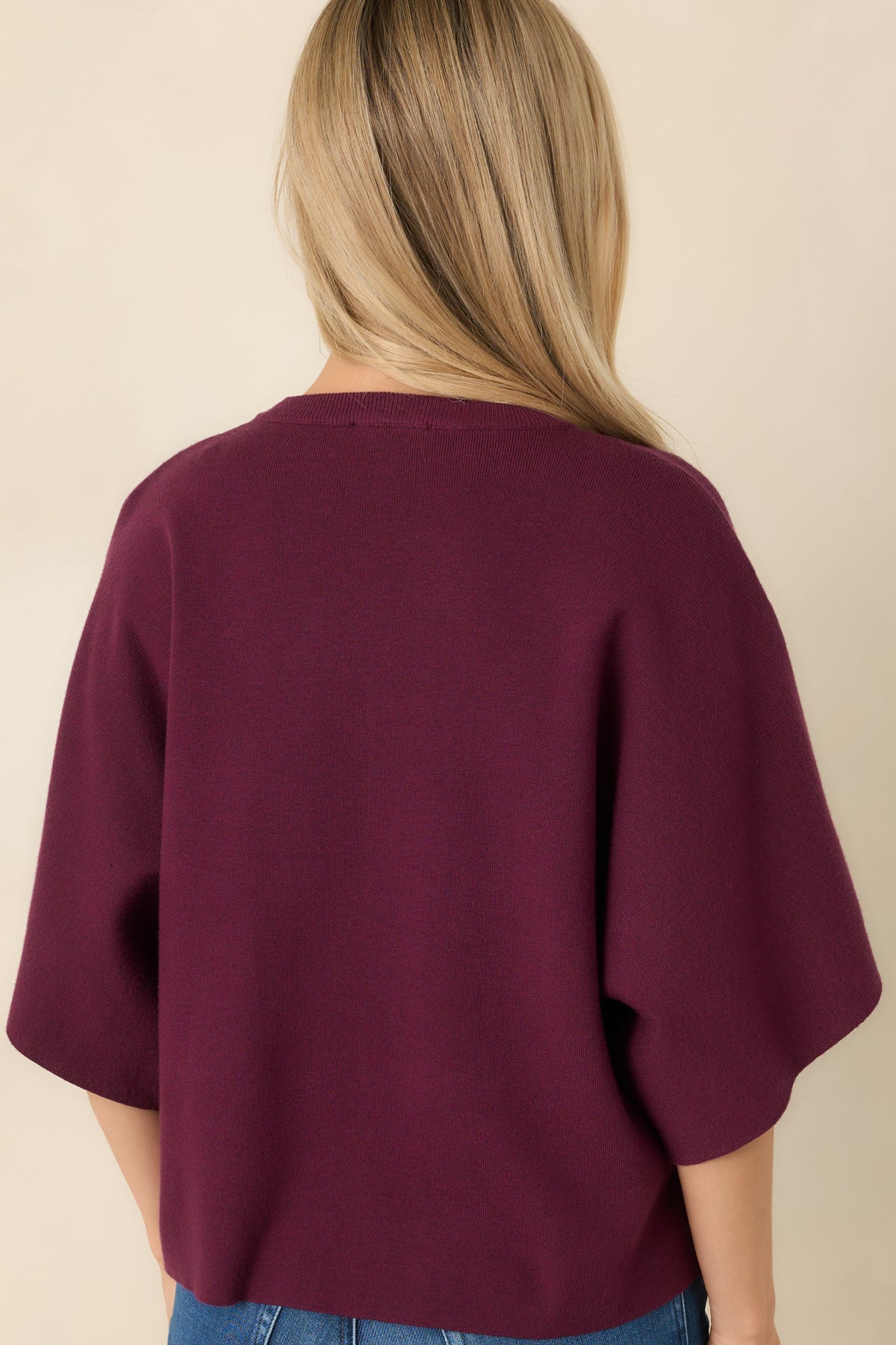 Relaxed boxy knit top with a wide round neckline, loose elbow-length sleeves, and a smooth back.