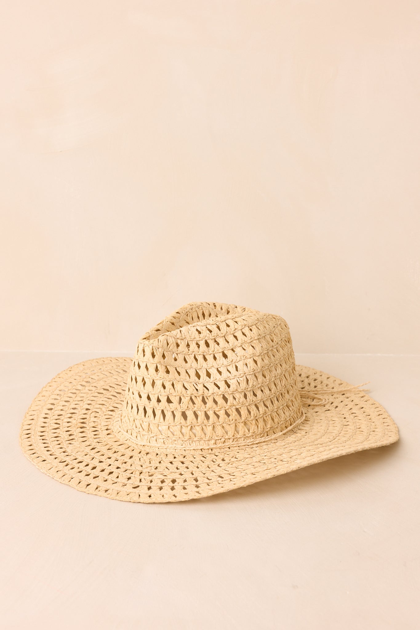Breathable ivory woven hat featuring a structured shape and lightweight straw construction displayed on beige.