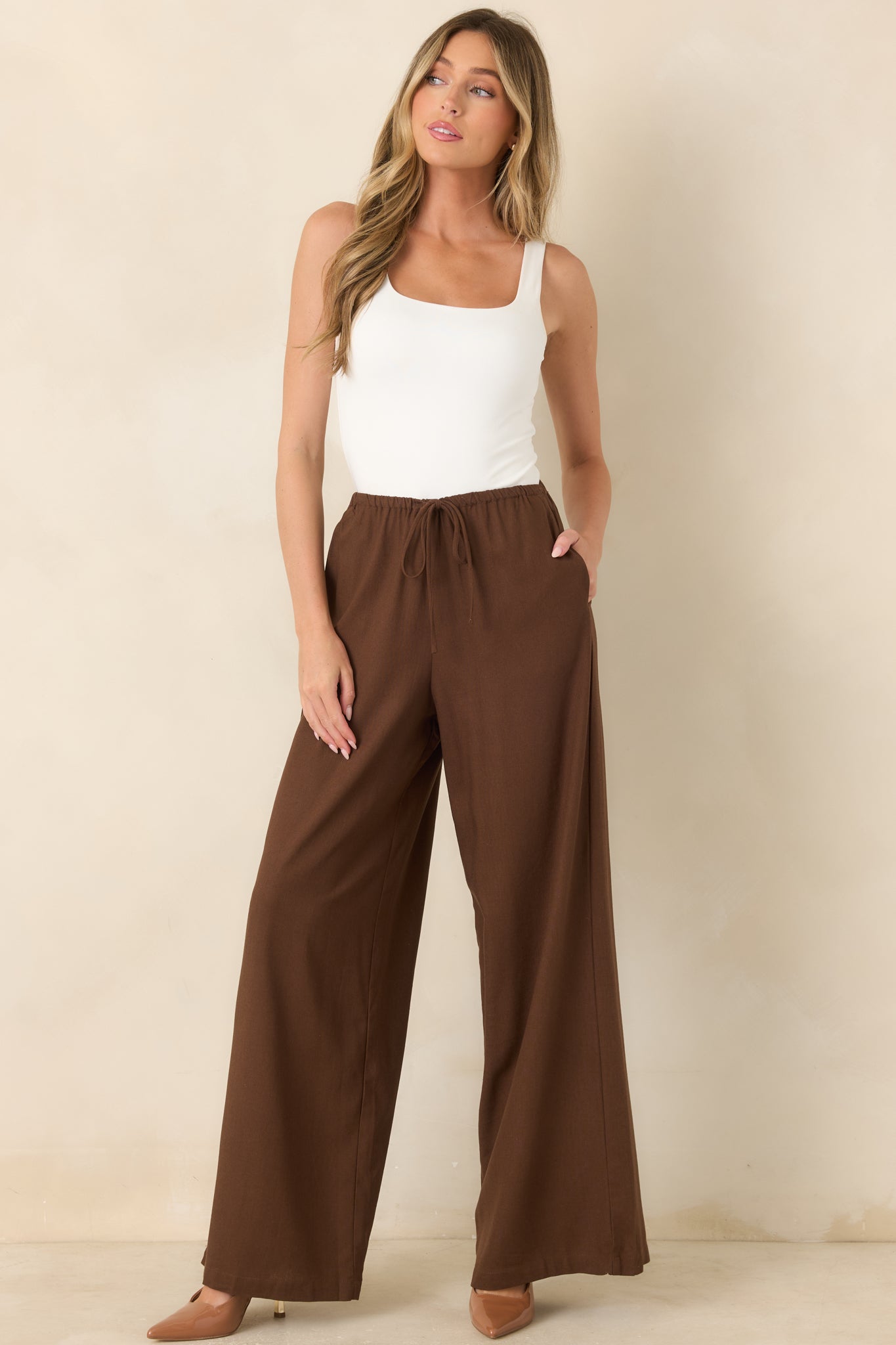 Breathable linen blend wide-leg pants featuring a relaxed silhouette, elastic waistband with decorative tie detail, smooth drape, and functional side pockets.