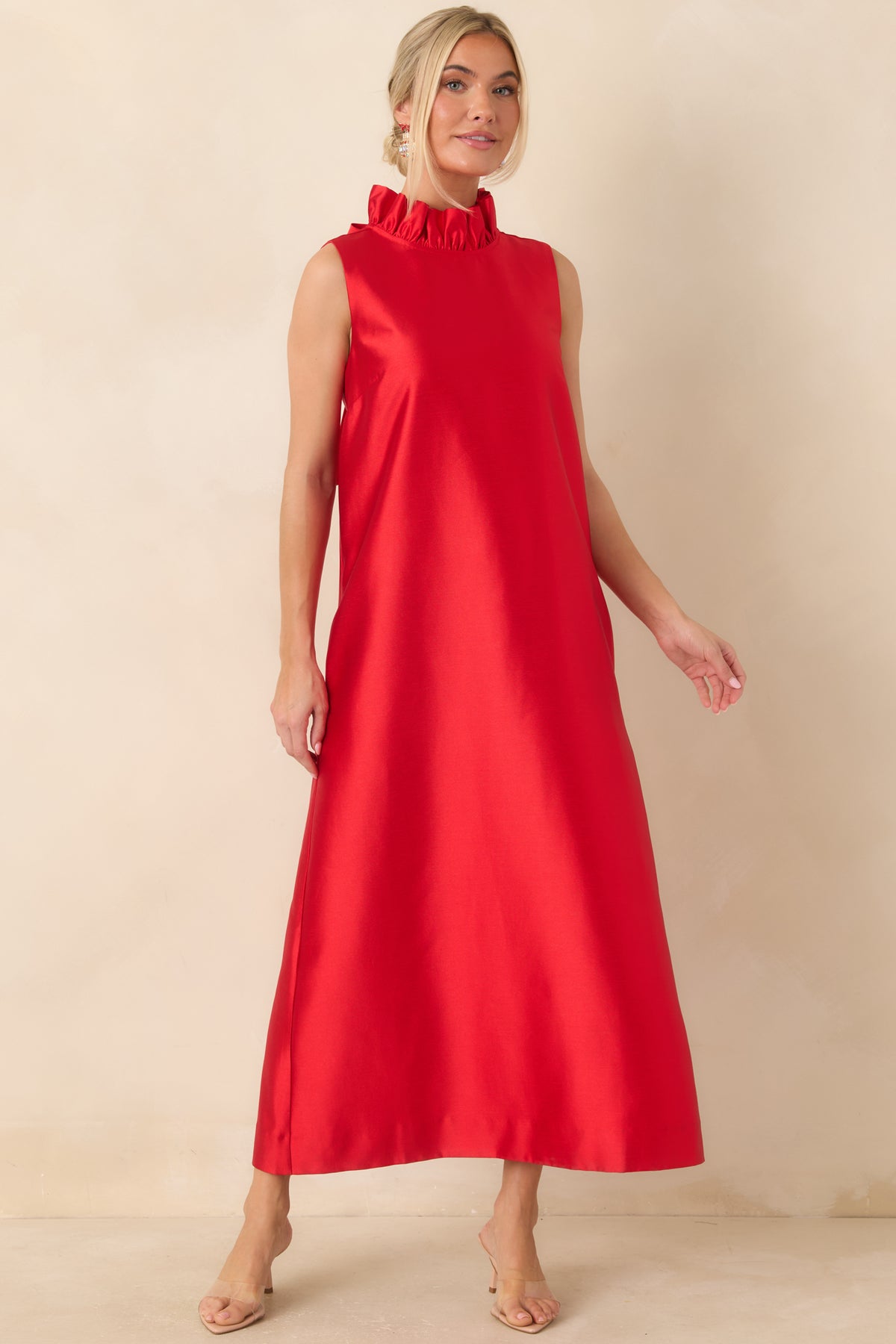 Bright red sleeveless dress with a ruffle-trimmed mock neckline and an elegant, full-length finish.