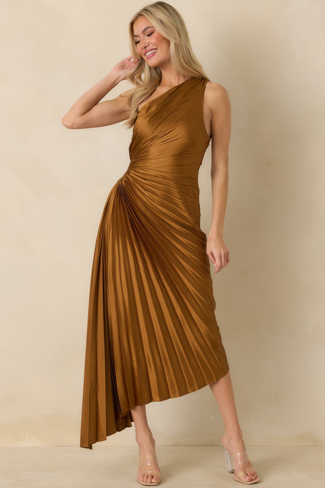 Front view of bronze maxi dress featuring an asymmetric one-shoulder neckline, pleated bodice, and flowing pleated skirt.