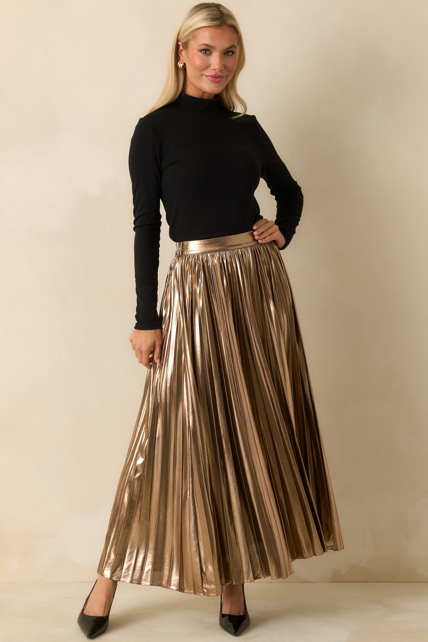 Shimmering bronze maxi skirt featuring an elasticized back waist for comfort and a high-rise, floor-length pleated design.