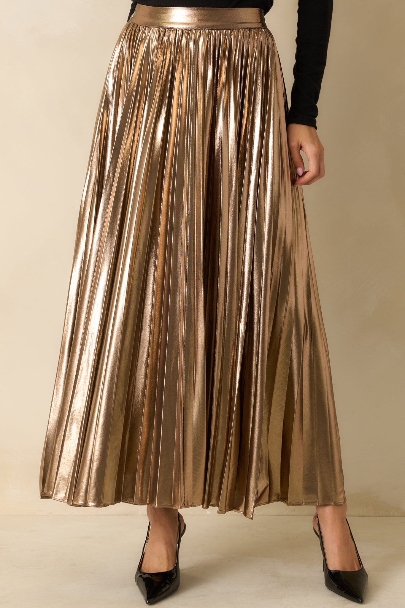 Crop highlighting the elastic back waist and detailed pleating of the skirt.