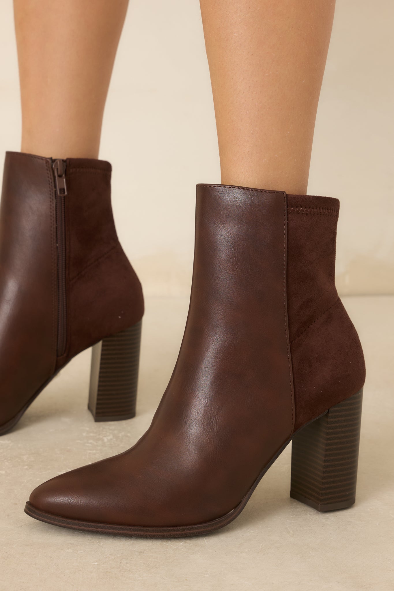Brown ankle boots featuring a smooth faux leather front, pointed toe, and a natural dark brown stacked block heel.