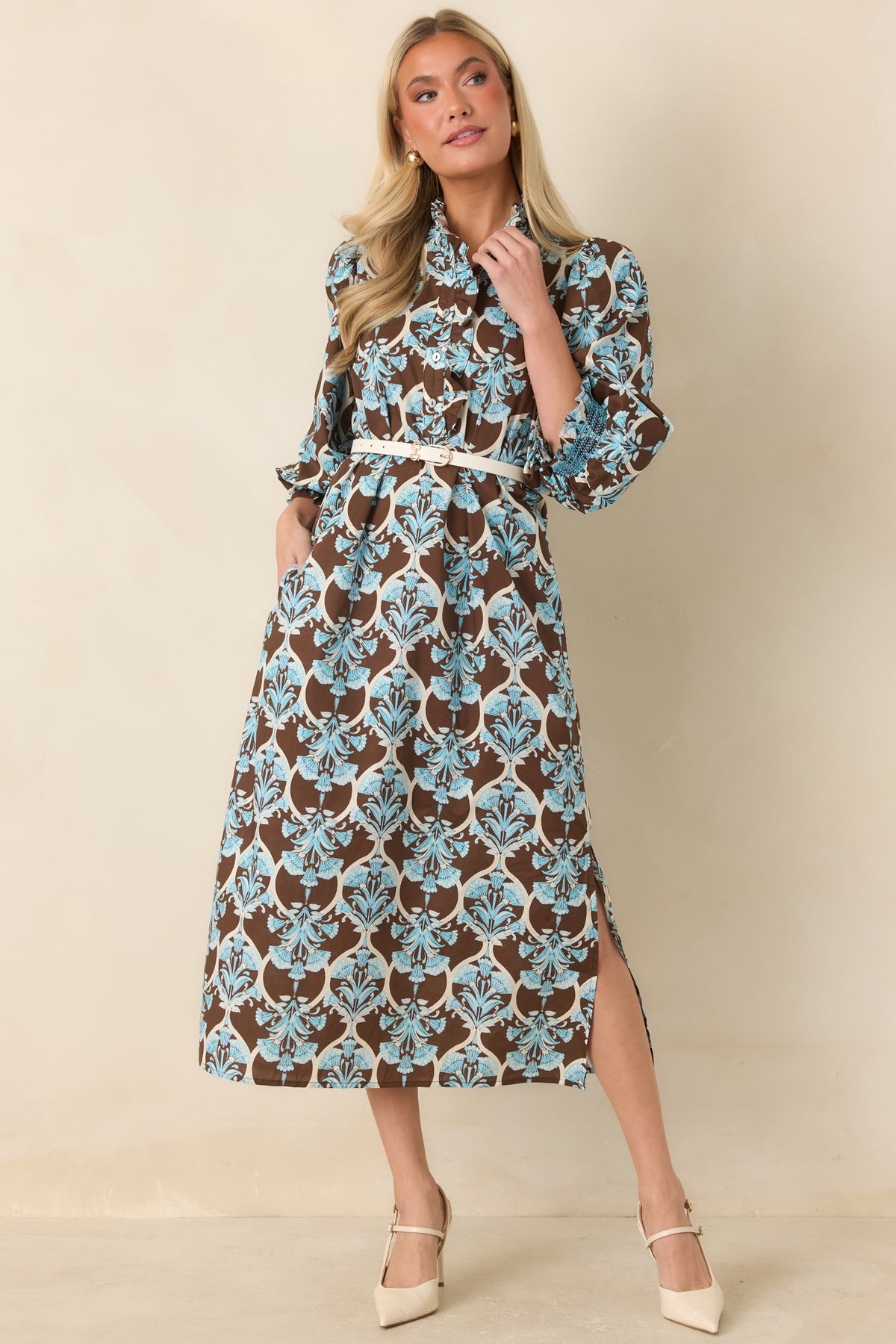 Brown floral midi dress with ornate blue blooms, ivory scrollwork, and a ruffled stand collar.