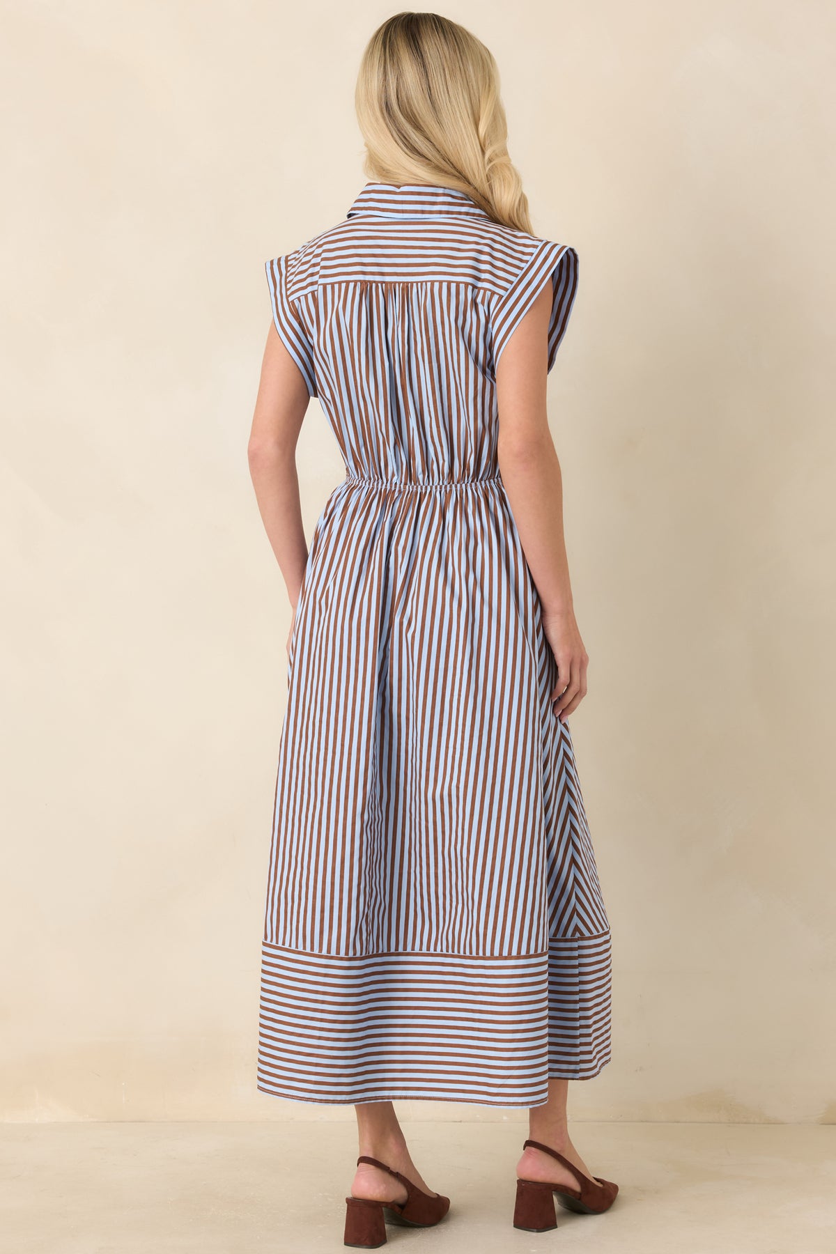 Rear of the brown and light blue striped midi dress showing the elastic back waistband and mixed stripe placement.