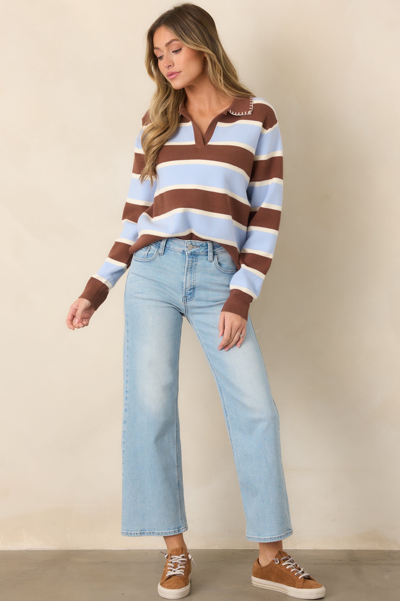 Bold color-blocked sweater featuring rich brown, soft blue, and white stripes, a contrasting stitched collar, full-length sleeves, and ribbed cuffs.