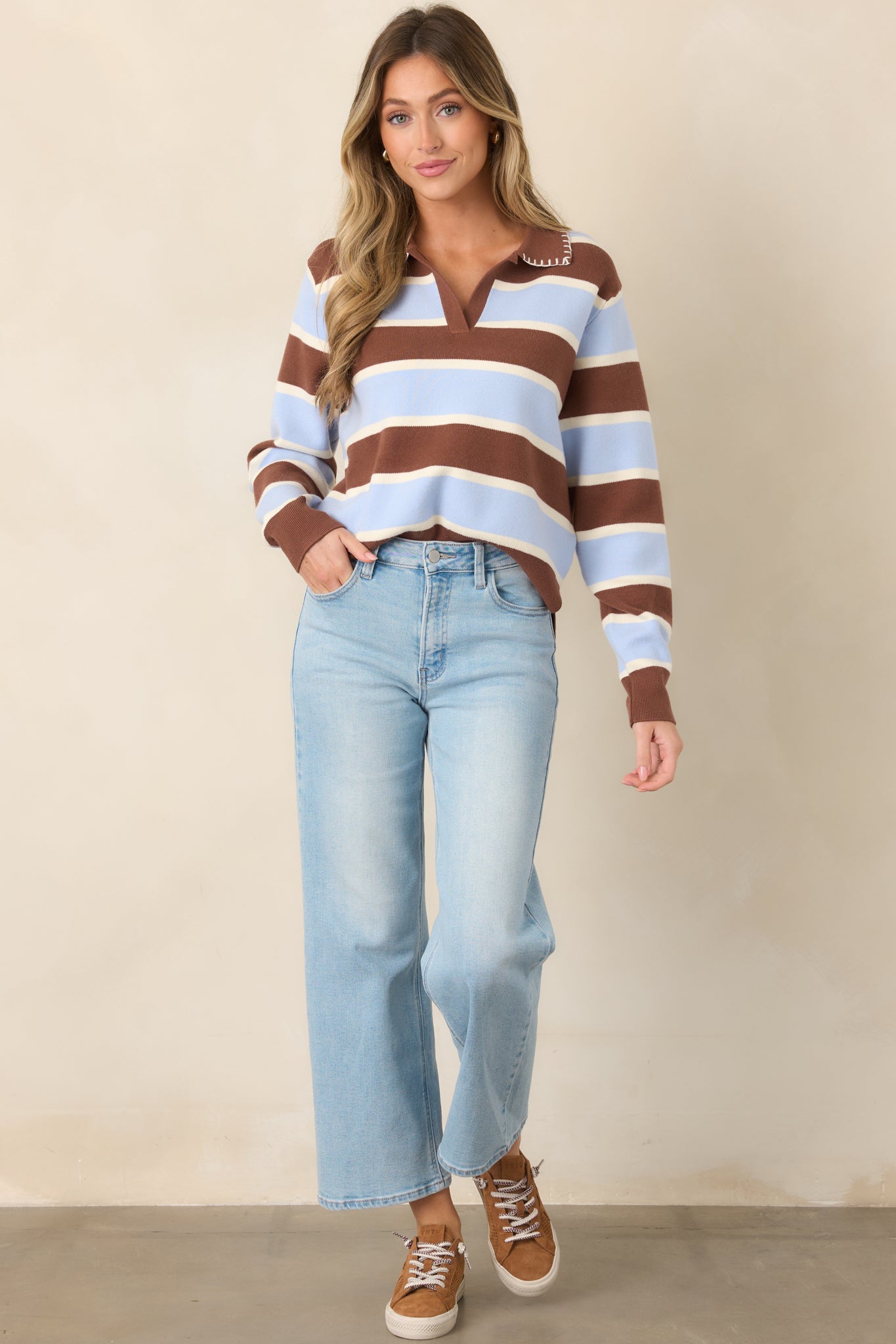 Relaxed knit top with wide horizontal bands of brown, light blue, and white, accented by a pointed brown collar, V-neckline, and long ribbed-cuff sleeves.