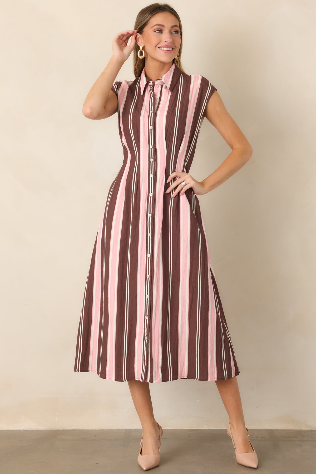 Brown, blush pink, and ivory vertical striped midi dress with a classic collar, cap sleeves, button-front design, defined waist, and gracefully flared skirt.