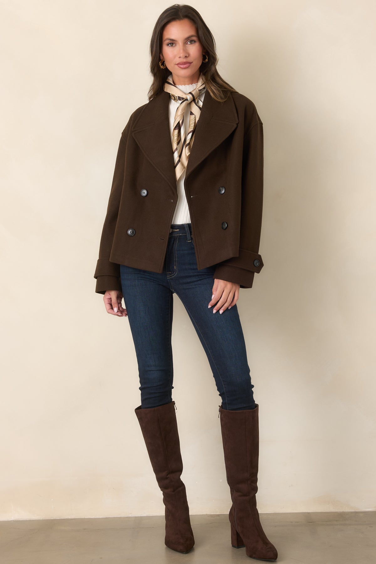 Relaxed brown jacket showcasing buttoned cuff tabs, side pockets, and a cropped hem.