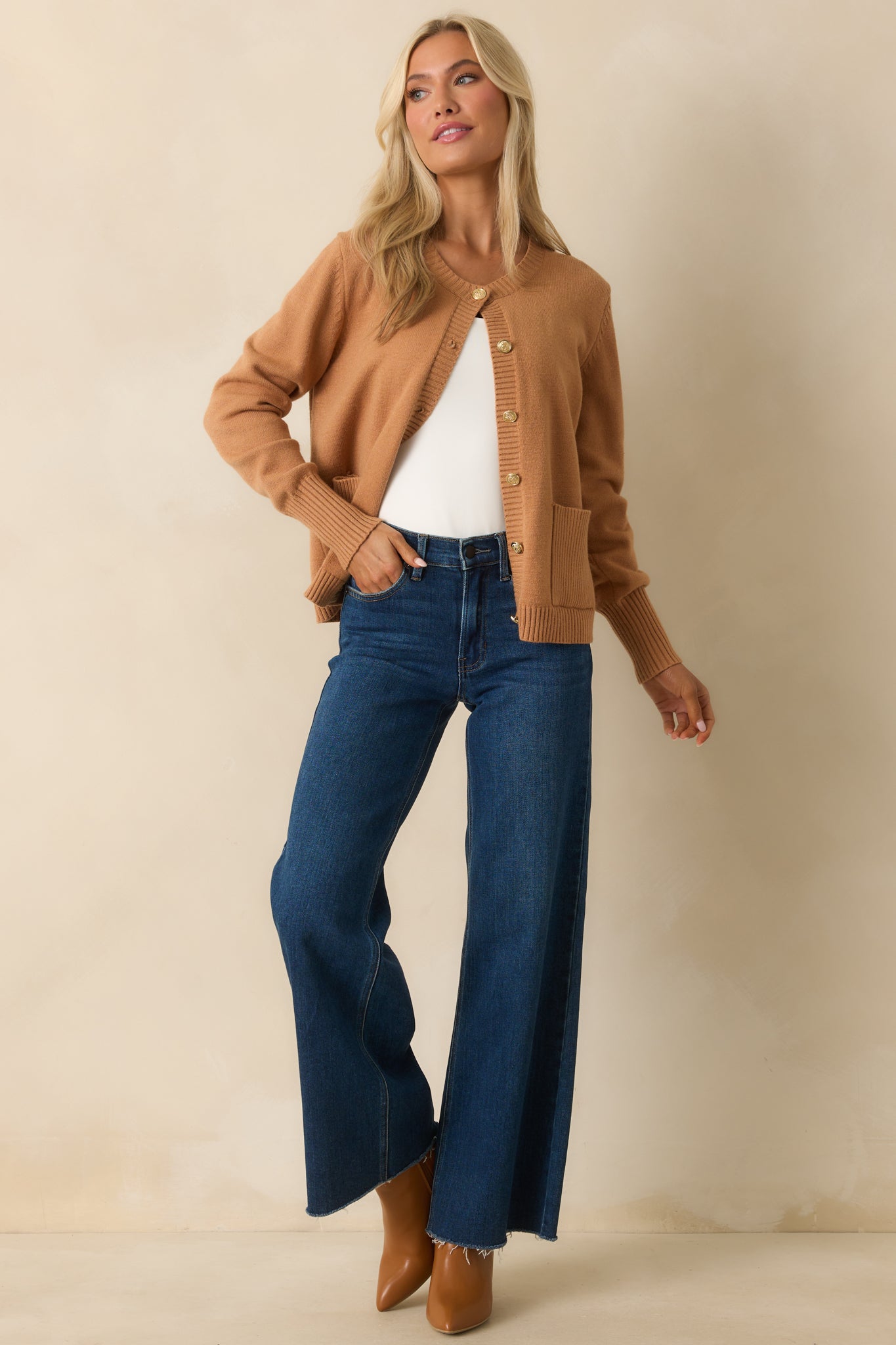 A front-facing image highlighting the embossed gold-tone button front on the brown cardigan.