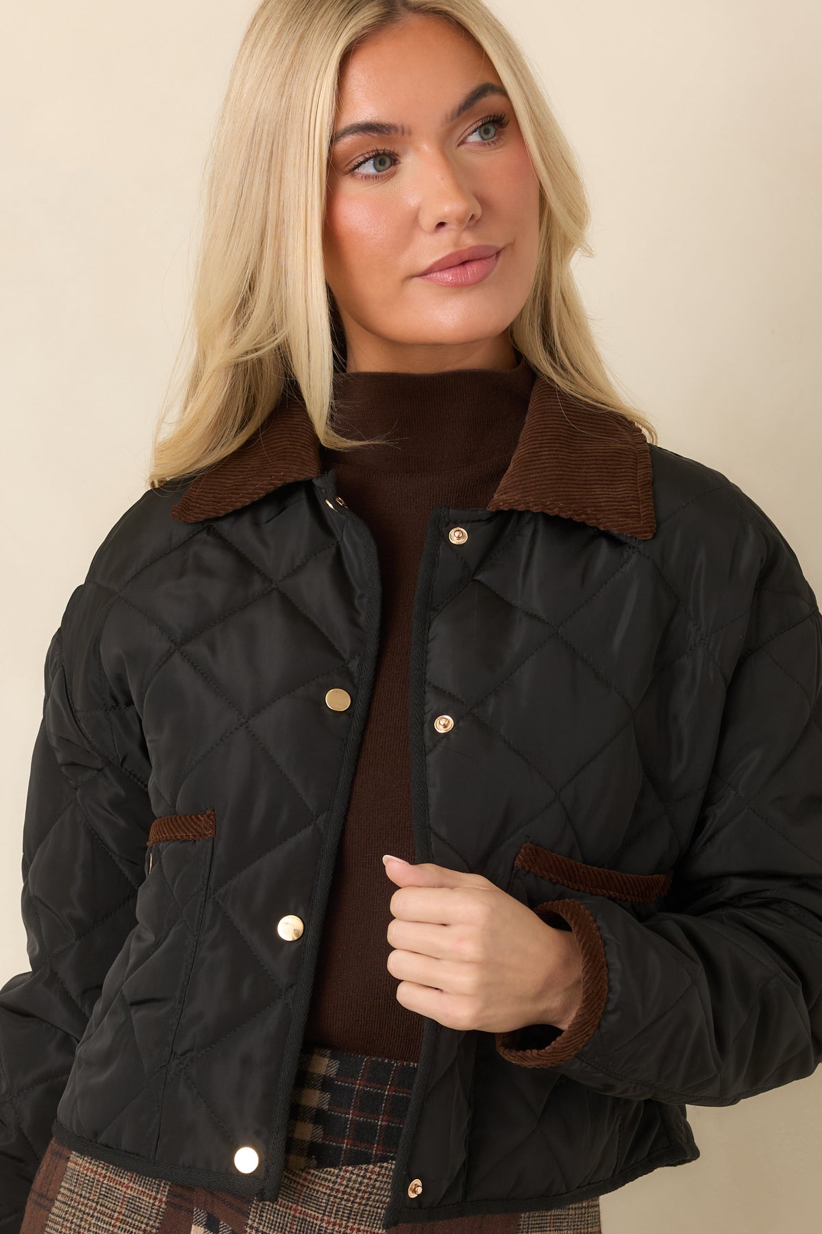 Brown collar sits above the diamond-stitched front and contrasting snap-button placket.