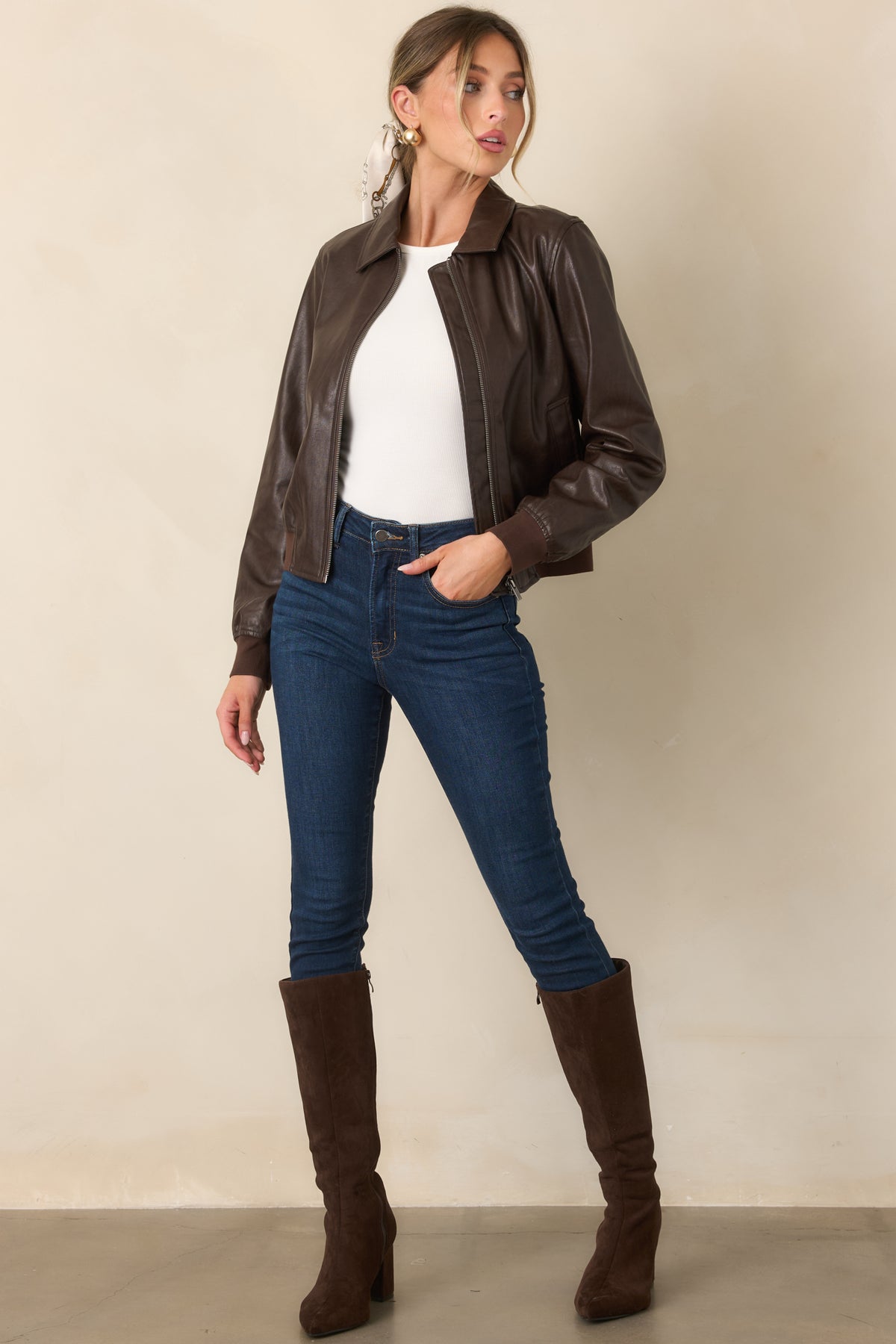 Collared brown bomber jacket with smooth faux leather, front zipper closure, clean welt pockets, and ribbed knit trim.